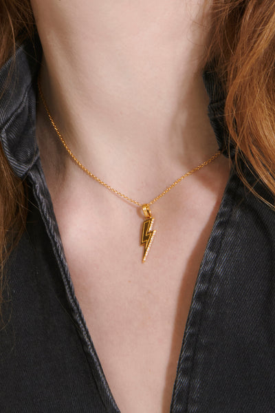 Scamp and Dude x Rachel Jackson Gold Plated Lightning Bolt Necklace with Champagne Pavé Detailing | Product image of gold lightning bolt necklace on woman's neck