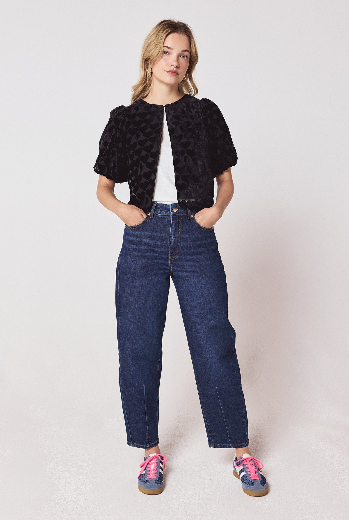 Scamp & Dude Black Heart & Bolt Burn Out Velvet Top | Model wearing a black velvet burn out top with a pair of barrel leg jeans and navy cheetah print trainers.