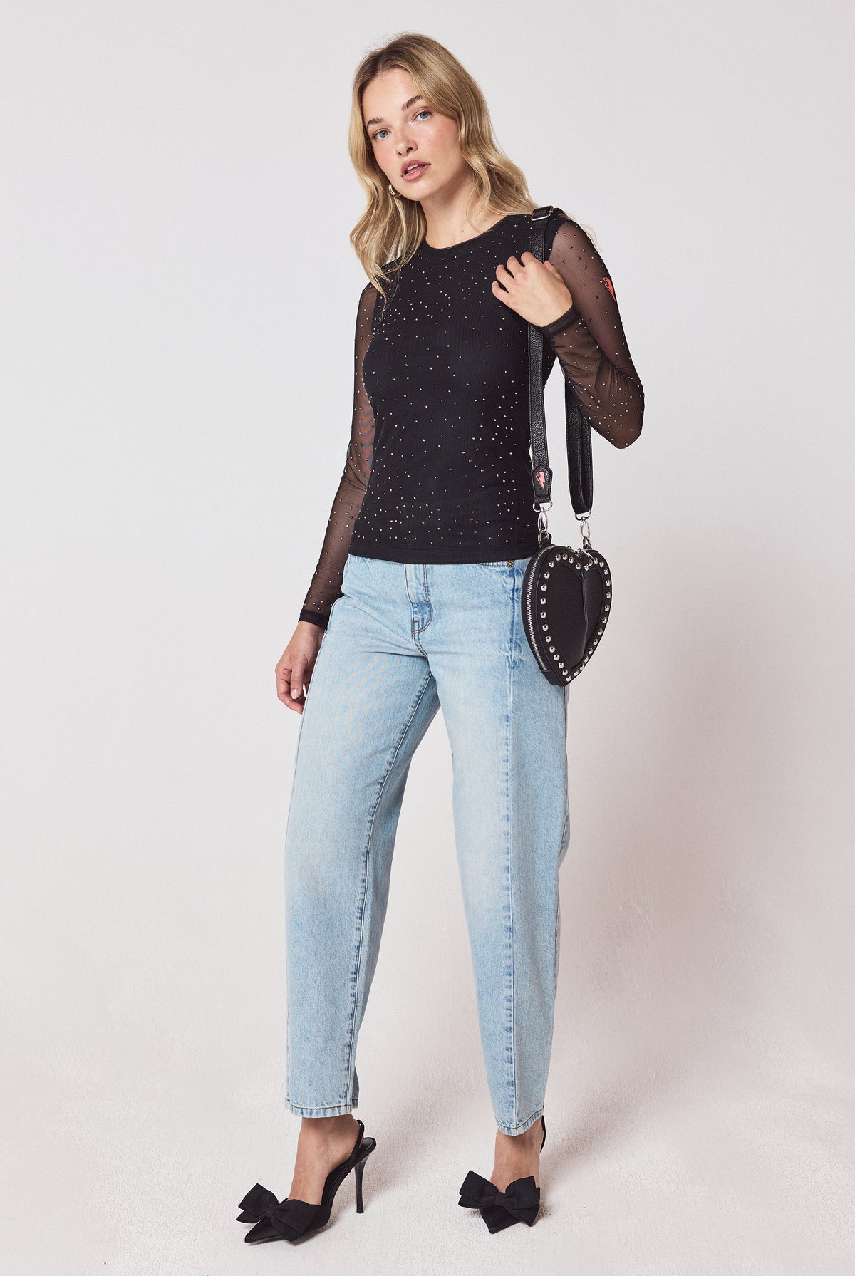 Scamp & Dude Black Embellished Mesh Top | Model wearing a black mesh top with pale blue jeans and black bow heels.