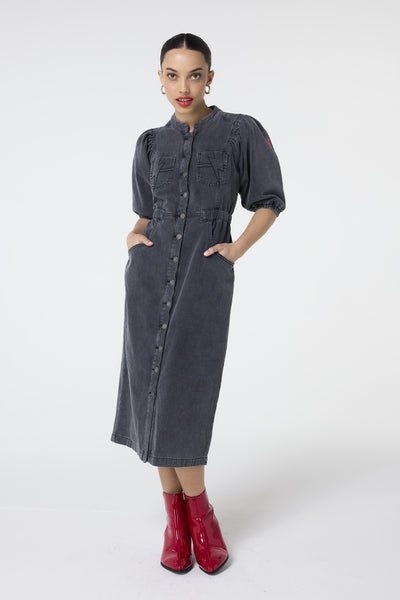 Scamp and Dude Washed Black Elastic Waist Denim Dress | Model wearing a washed black denim dress with lightning bolt pocket detail and an elasticated waist.