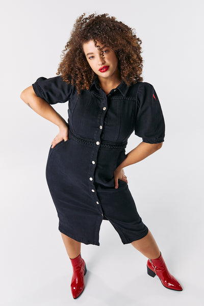 Scamp and Dude Black Plait Detail Denim Dress | Model with curly hair wearing black denim midi dress with red pointy boots