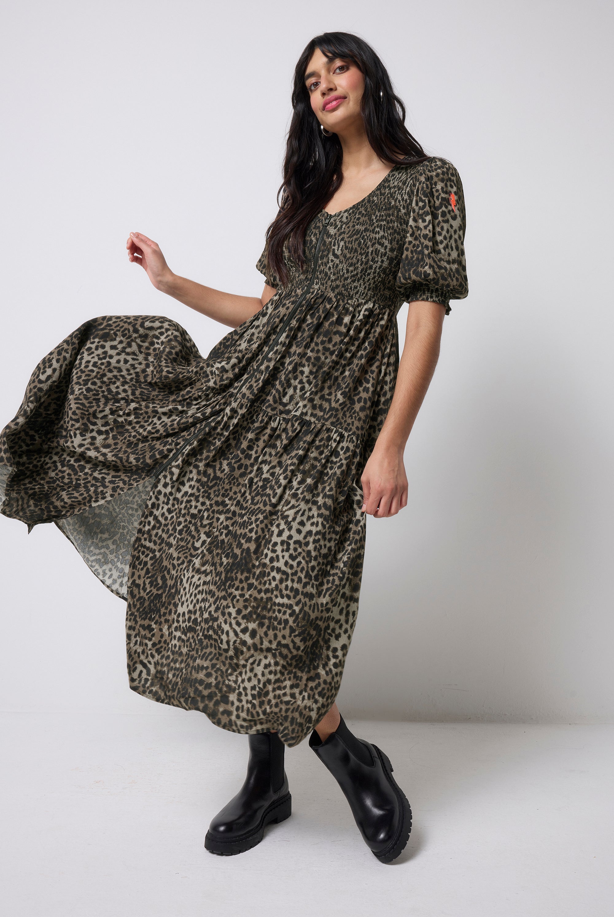 Scamp and Dude Khaki Cheetah Shirred Zip Detail Midi Dress | Model wearing a khaki shirred zip front midi dress in a cheetah print with chunky black boots.