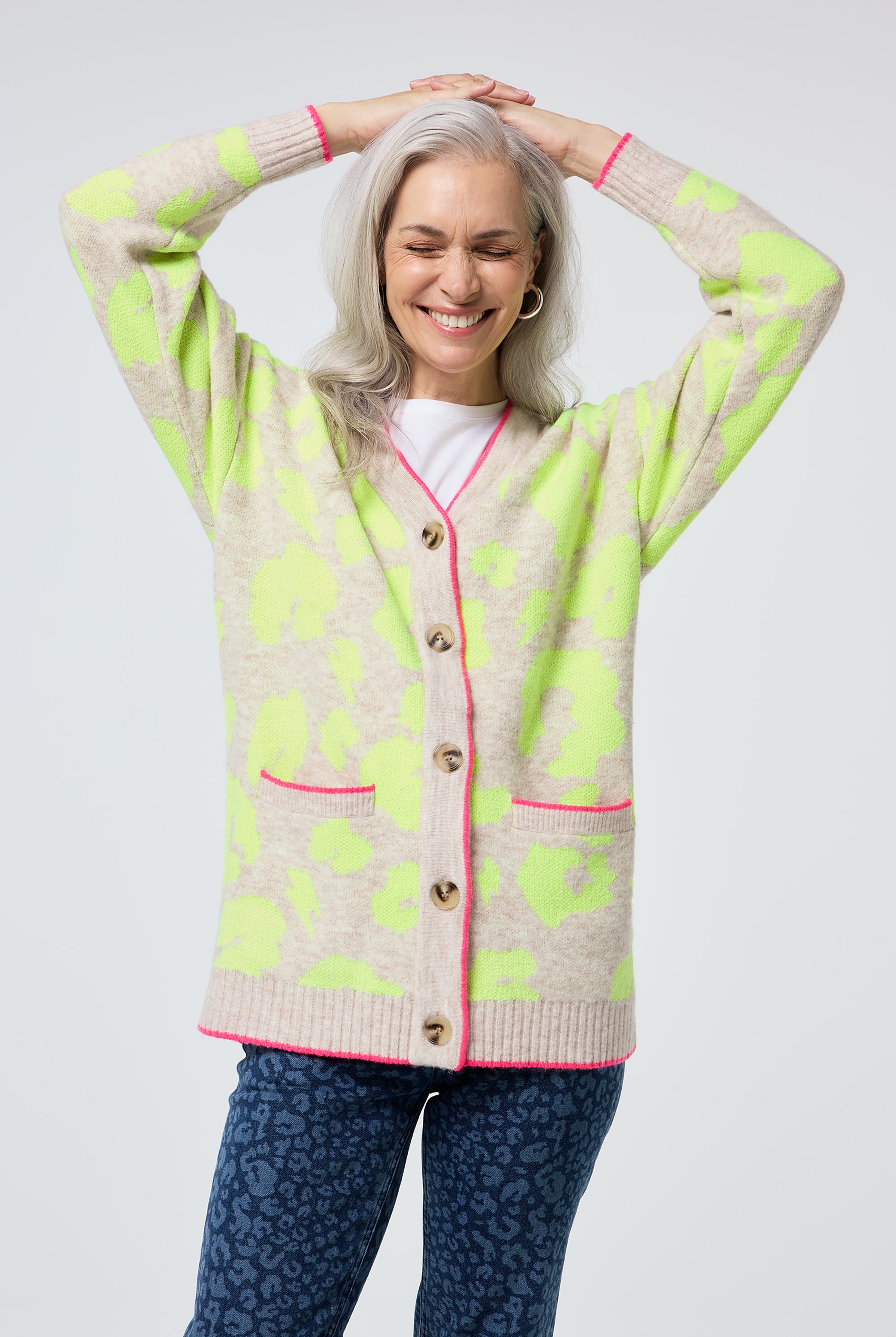 Scamp and Dude Oatmeal with Neon Yellow Mega Leopard Longline Jacquard Cardigan | Model wearing a longline cardigan featuring neon yellow leopard print, paired with a white t shirt and leopard print jeans.