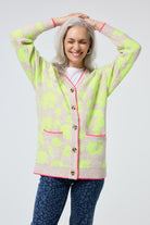 Scamp and Dude Oatmeal with Neon Yellow Mega Leopard Longline Jacquard Cardigan | Model wearing a longline cardigan featuring neon yellow leopard print, paired with a white t shirt and leopard print jeans.