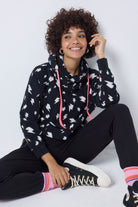 Scamp and Dude Black with White Lightning Bolt Cowl Neck Hoodie | Model wearing a black hoodie with a white lightning bolt print and coral drawstrings, paired with black joggers.