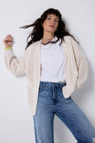 Scamp and Dude Cream Star and Lightning Bolt Knitted Crotchet Cardigan | Model wearing a pair of distressed blue jeans with a white r-shirt and cream knitted cardigan.