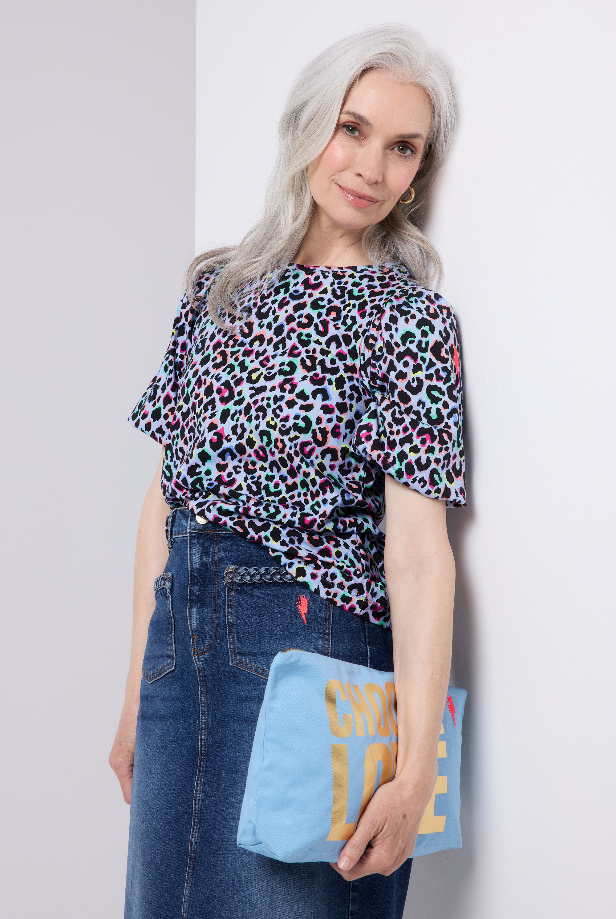 Scamp and Dude Light Blue with Rainbow Shadow Leopard Puff Sleeve T-Shirt | Model wearing a light blue puff sleeve t shirt featuring rainbow leopard print. Worn with a denim midi skirt and trainers.