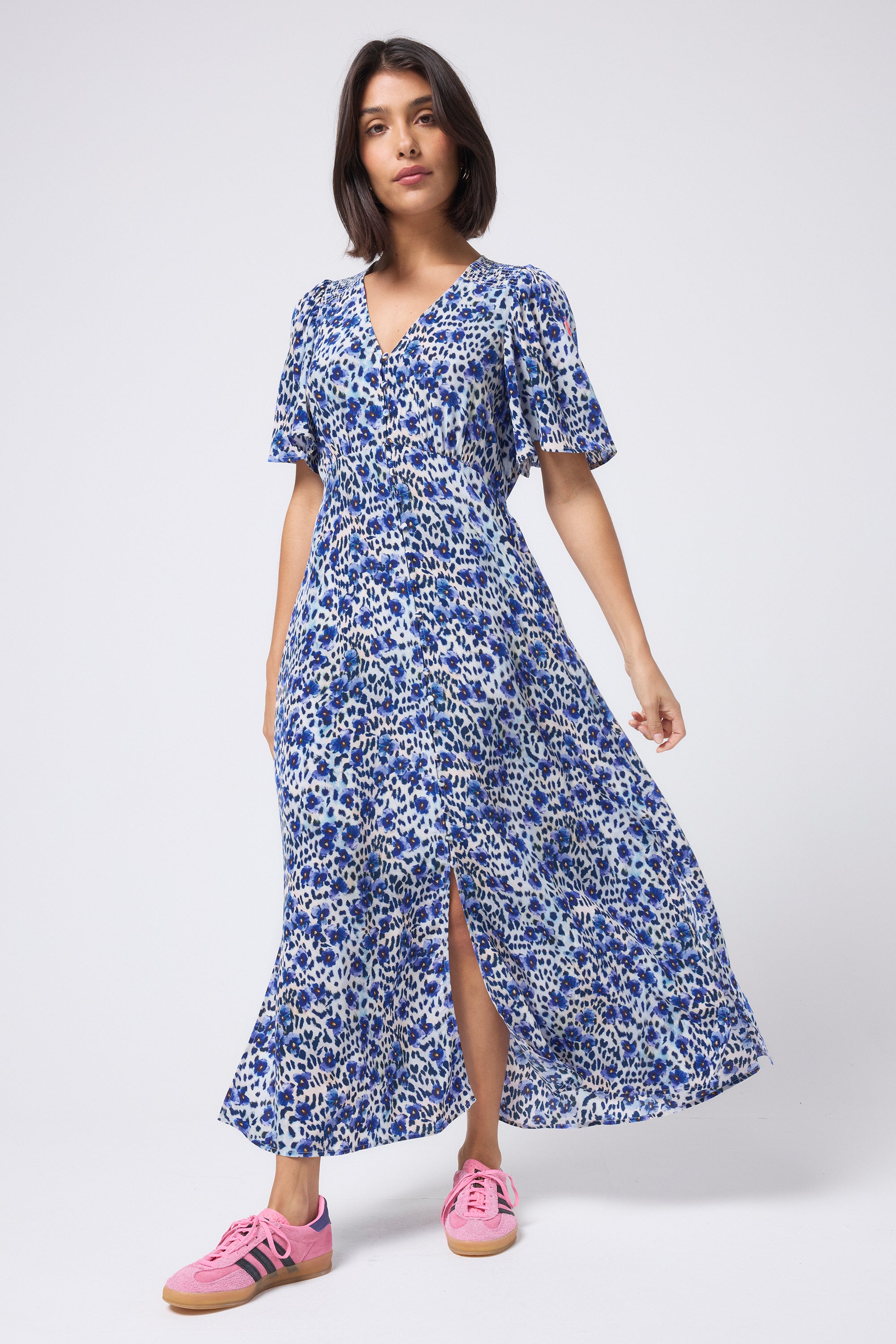 Scamp and Dude White with Blue Floral Animal Print Angel Sleeve Midi Tea Dress | Model wearing a short sleeve white midi tea dress featuring floral and animal print. Worn with pink trainers.