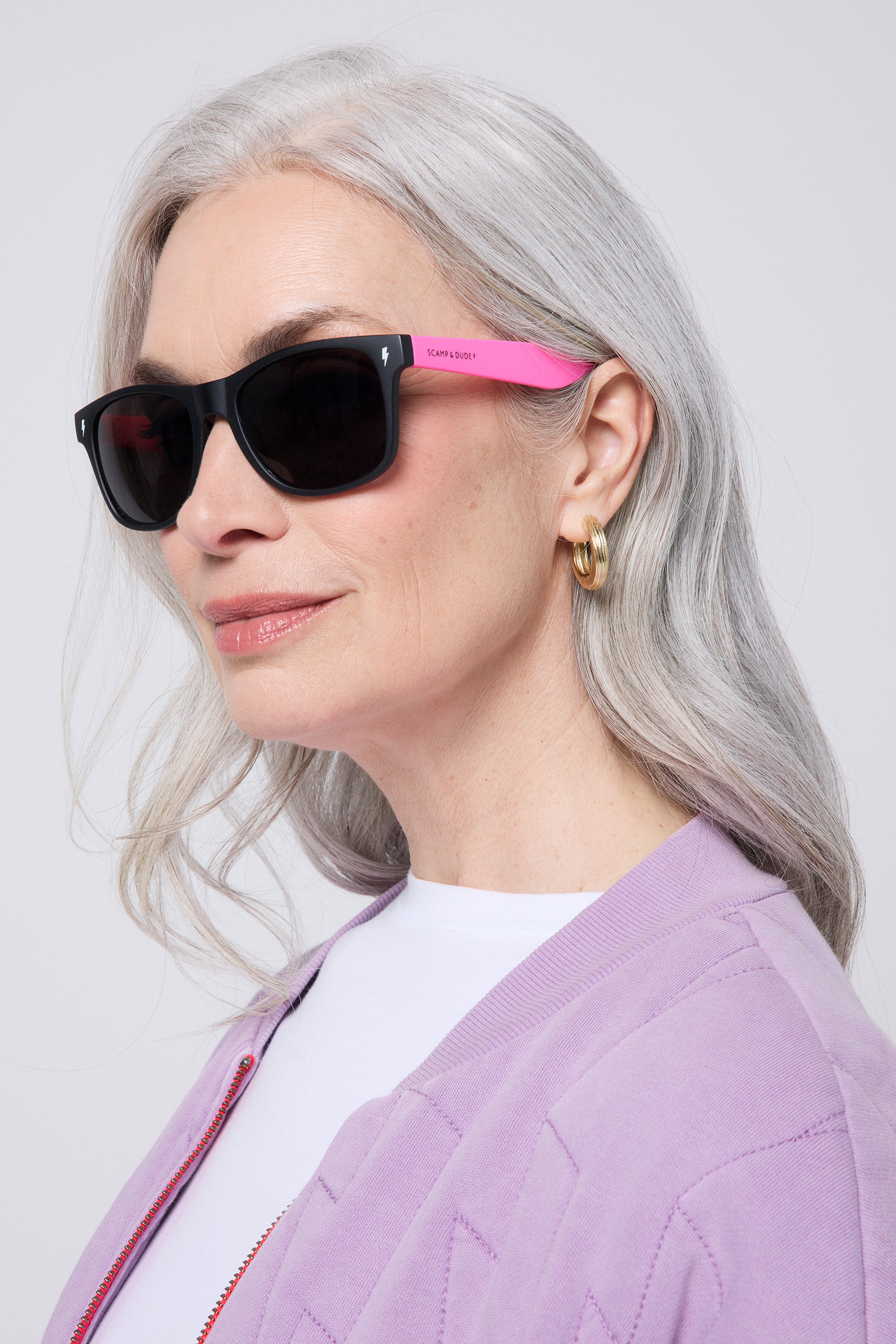 Scamp and Dude 'Neon Sunnies' Black with Orange and Neon Pink | Model wearing black sunglasses with orange and neon pink detail.