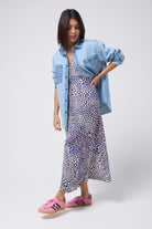 Scamp and Dude Pale Indigo Relaxed Denim Shirt | Model wearing an animal print dress with a mixed wash pale blue denim shirt.