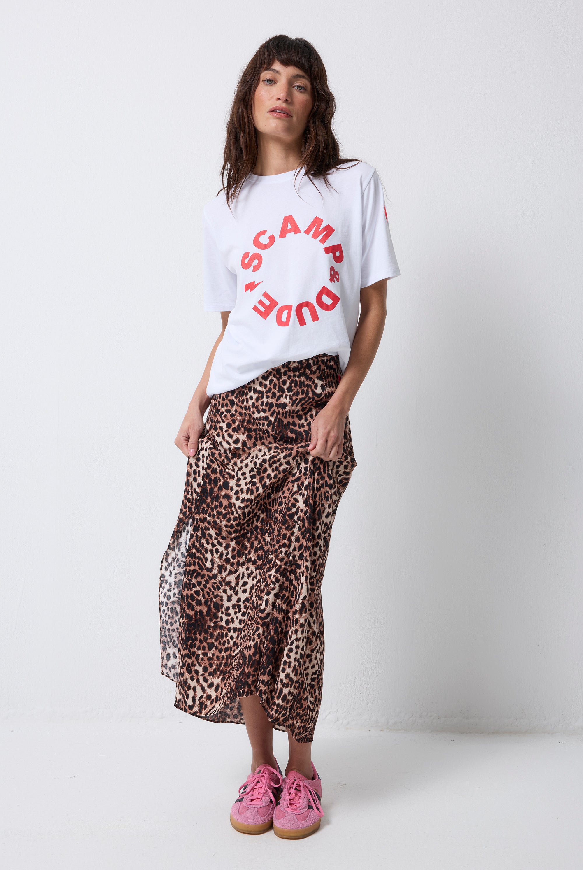 Scamp and Dude White with Red Scamp & Dude Logo T-Shirt | Model wearing a neutral cheetah print skirt with a white t shirt and red Scamp & Dude logo.