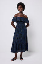 Scamp and Dude Navy with Black Rock and Roll Leopard Lurex Bardot Midi Dress  | Model wearing a dark navy bardot dress featuring black leopard print ad lurex stripe detail. Paired with black slip on sandals.