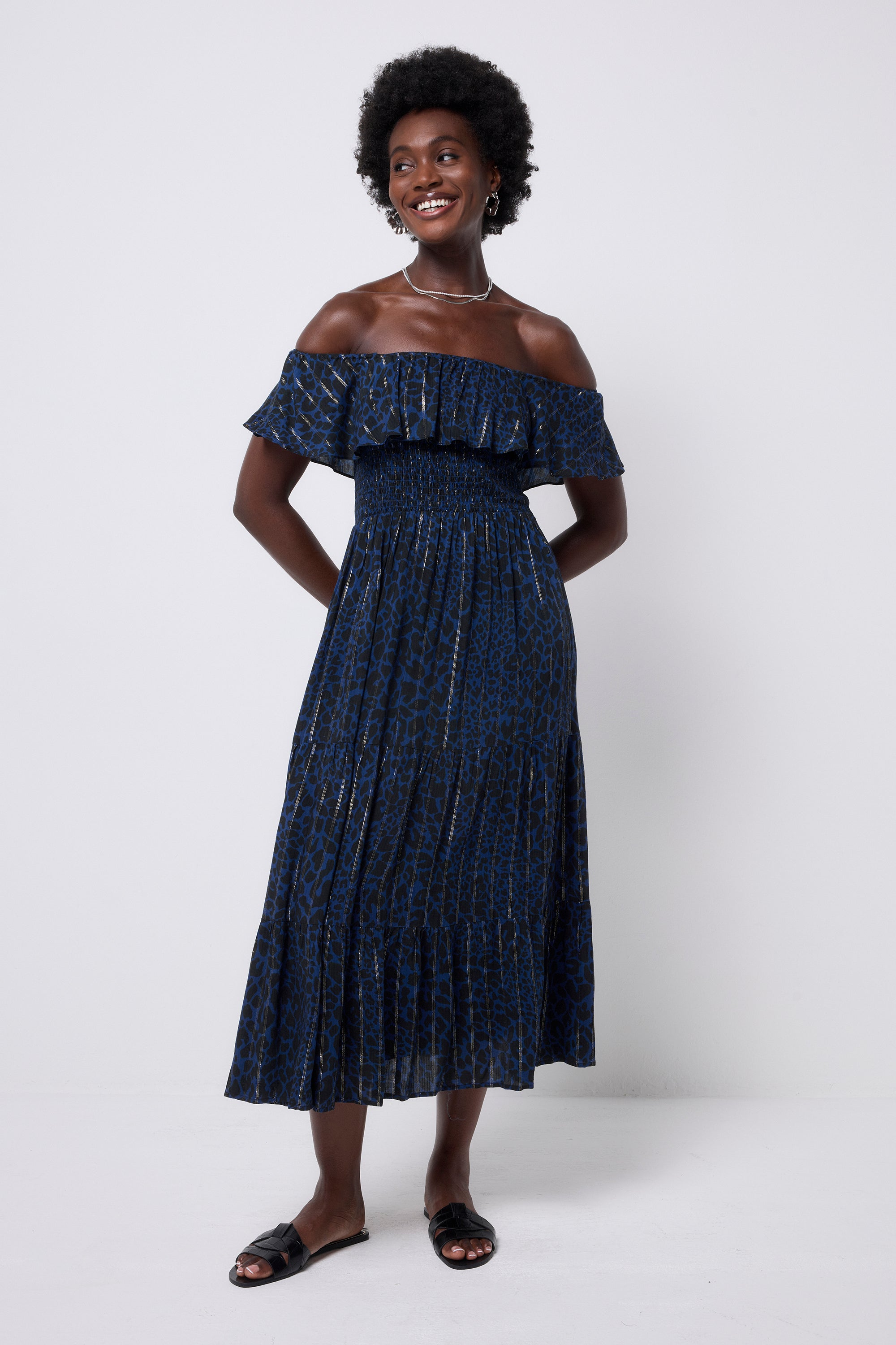 Scamp and Dude Navy with Black Rock and Roll Leopard Lurex Bardot Midi Dress  | Model wearing a dark navy bardot dress featuring black leopard print ad lurex stripe detail. Paired with black slip on sandals.