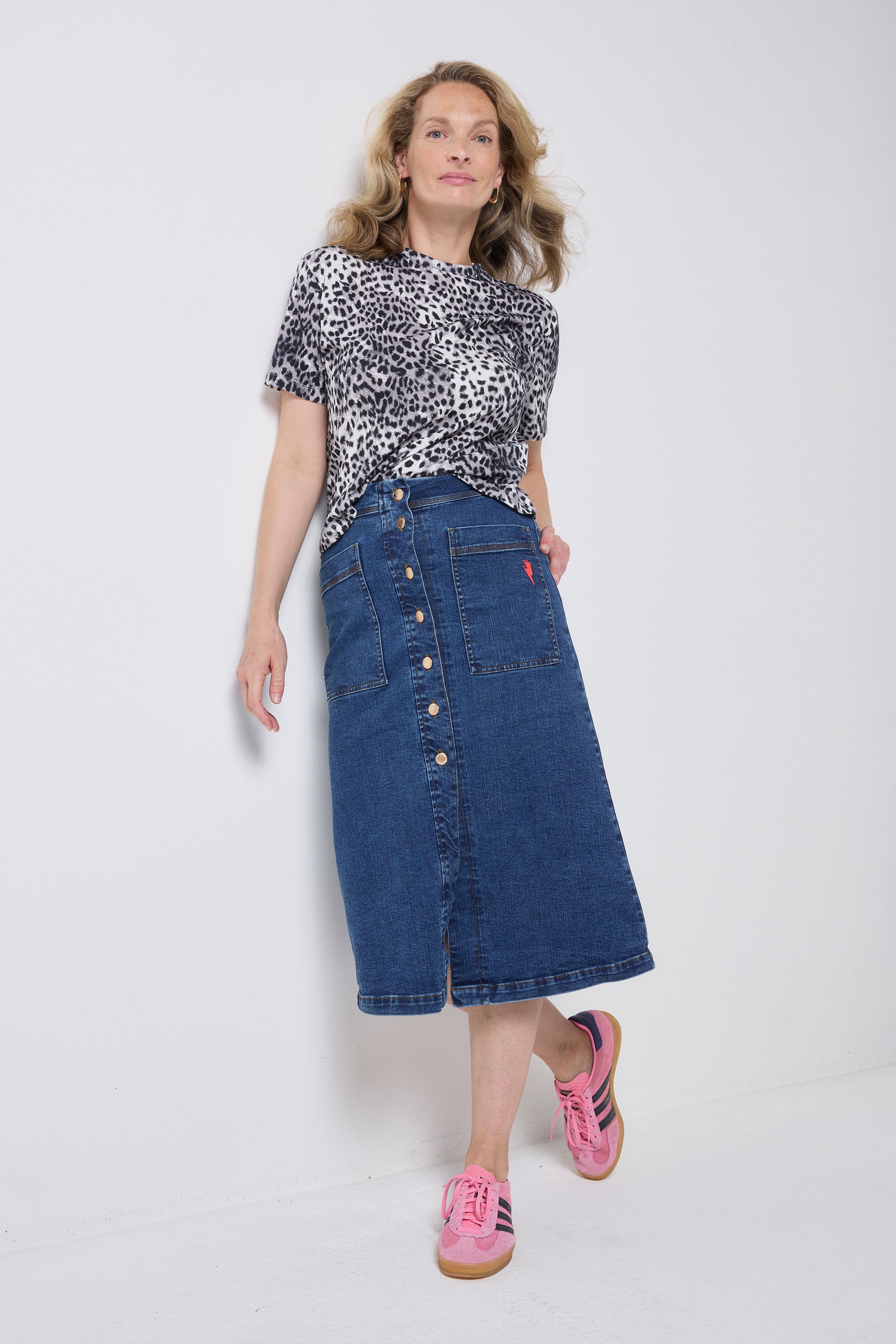 Scamp and Dude Authentic Indigo Button Front A-Line Denim Midi Skirt | Model wearing a blue denim button front skirt with a grey, white and black cheetah print t-shirt.