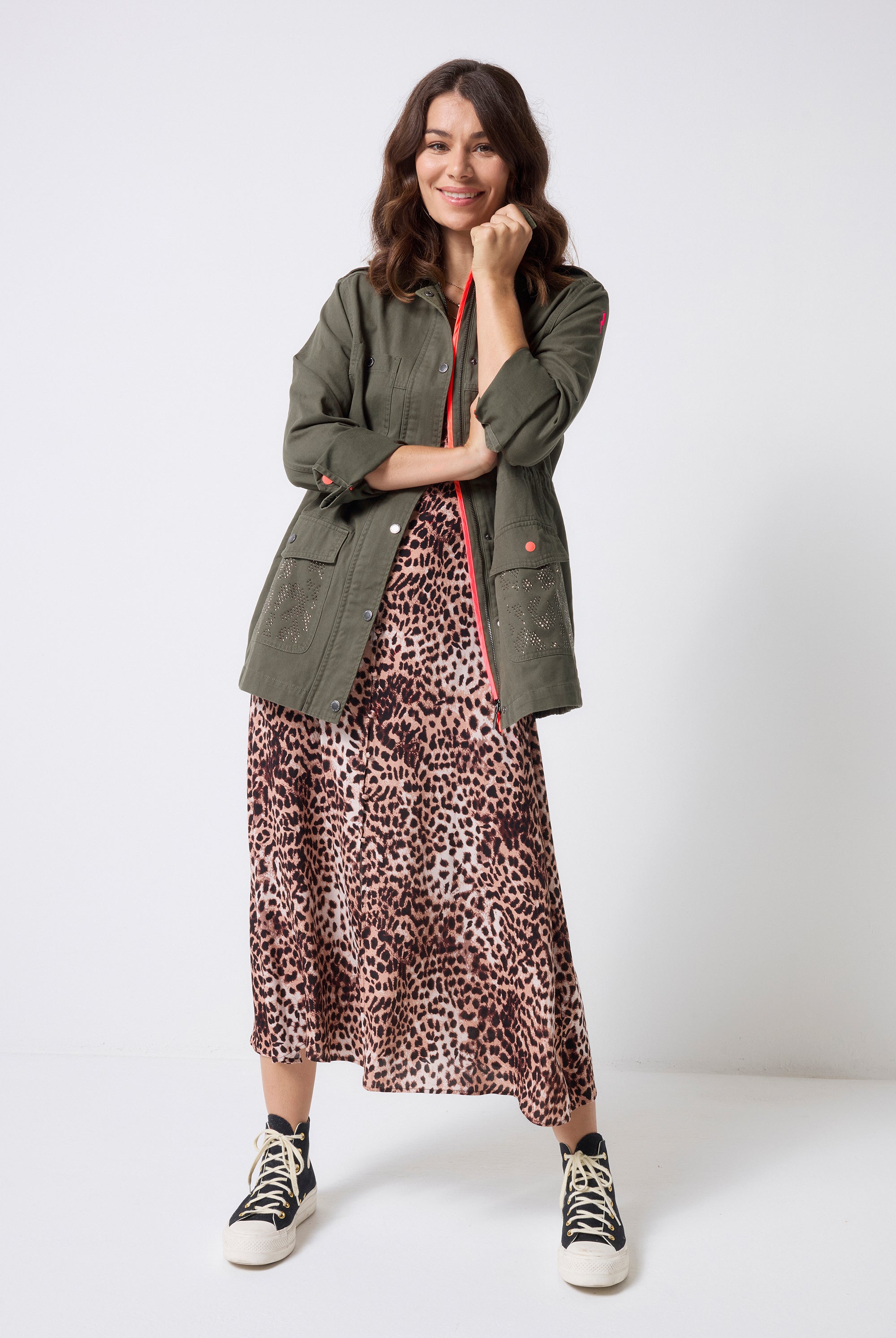Scamp and Dude Khaki with Studded Bolt Utility Jacket | Model wearing a neutral cheetah midi dress with a khaki studded utility jacket and black trainers.