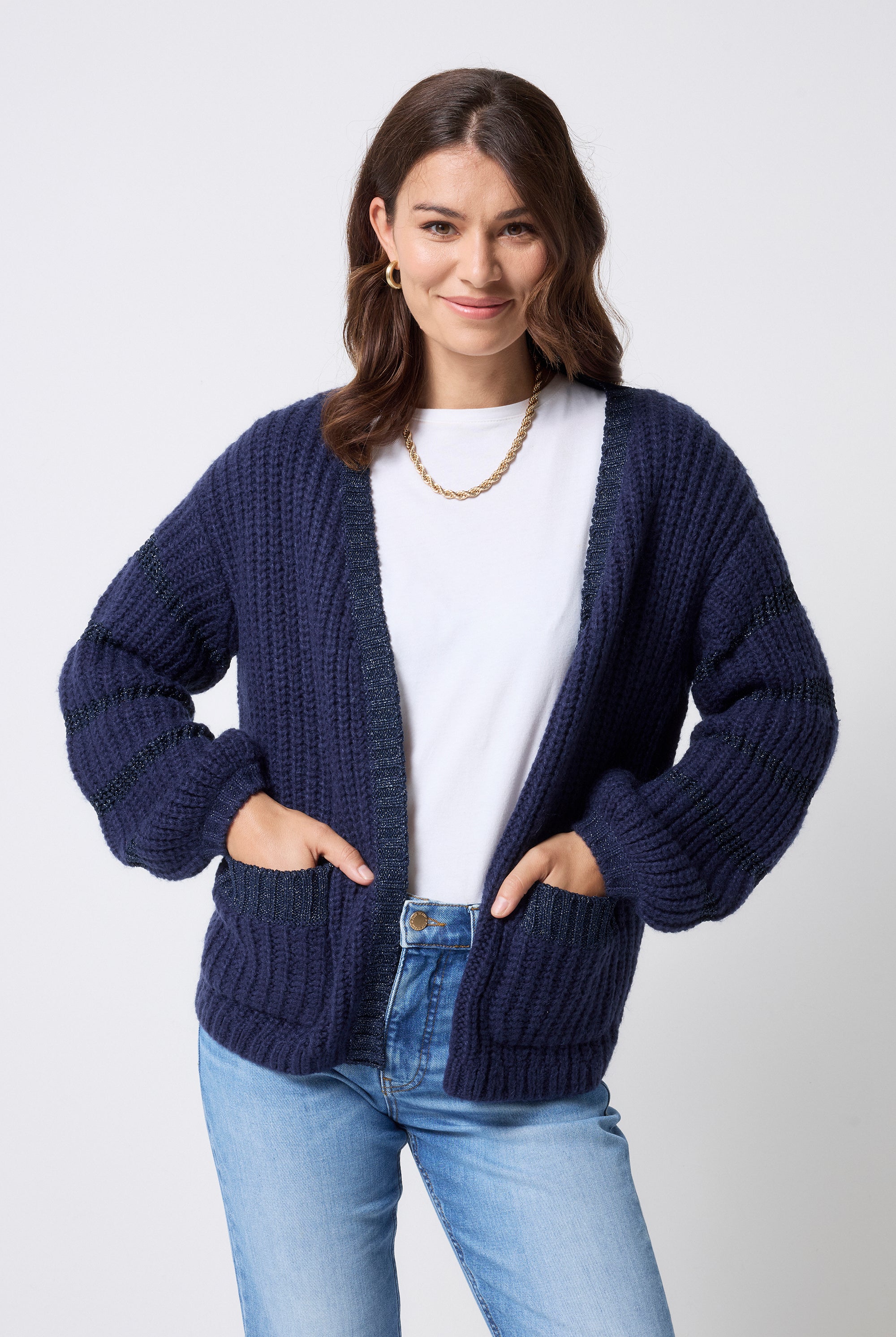 Scamp and Dude Navy Lurex Stripe Edge to Edge Cardigan | Model wearing a pair of light blue jeans with a white t-shirt and navy cardigan featuring lurex detail.