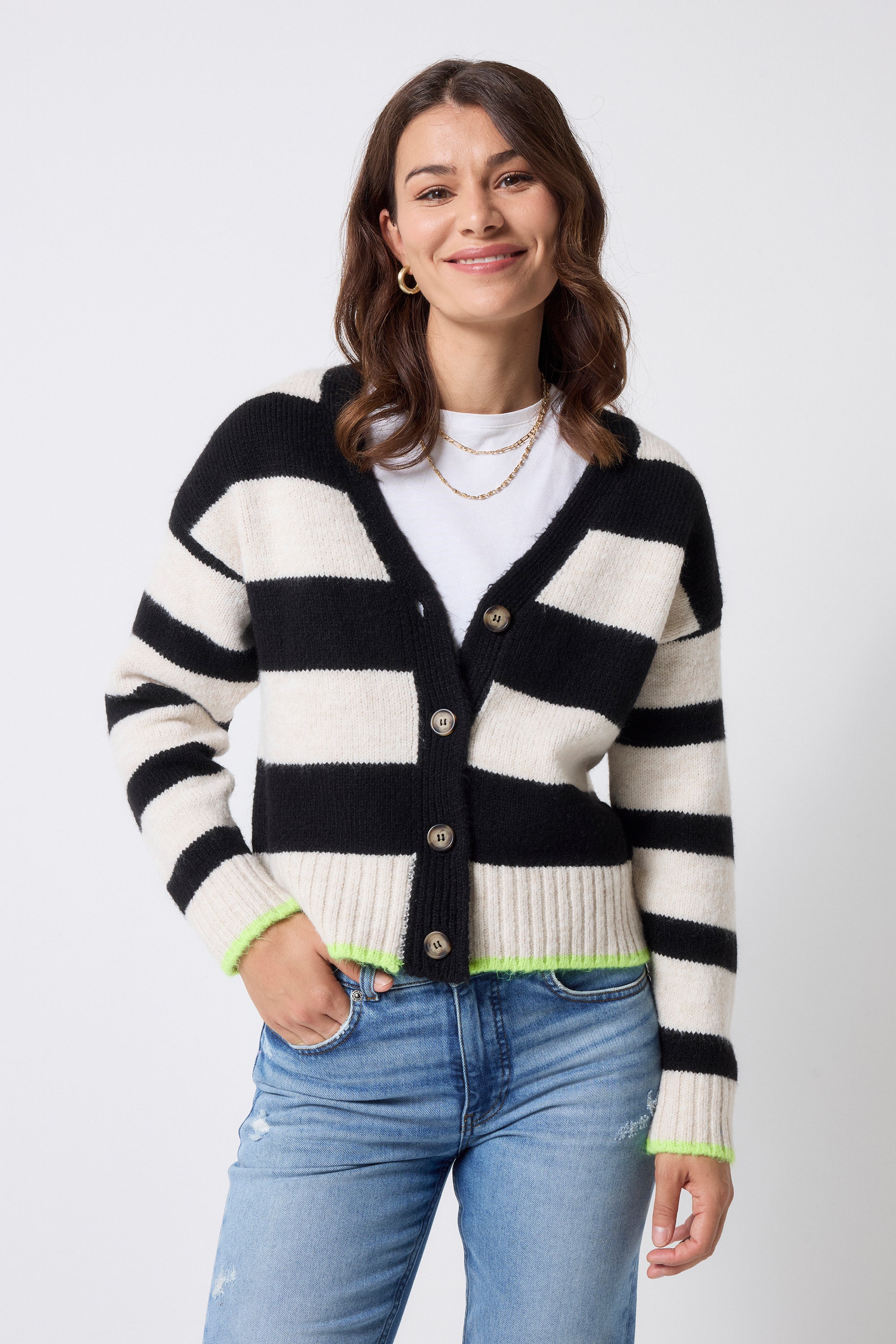 Scamp and Dude Cream with Black Bold Stripe Cardigan | Model wearing a pair of light blue denim jeans with a white t-shirt, gold jewellery and a black and cream stripe cardigan.
