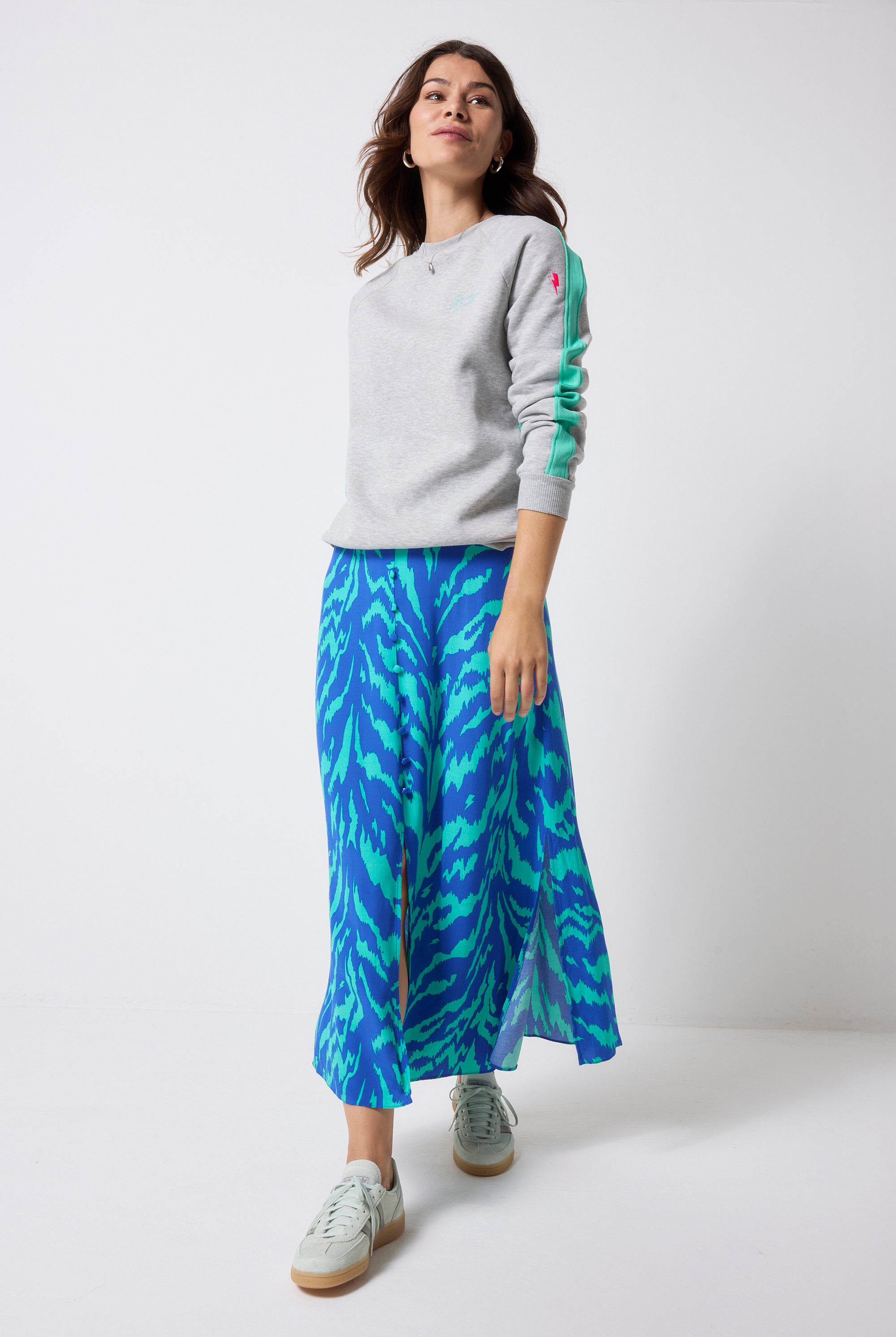 Scamp and Dude Grey Marl with Turquoise Colourblock Relaxed Sweatshirt | Model wearing a grey crewneck sweatshirt with a blue and green tiger skirt.