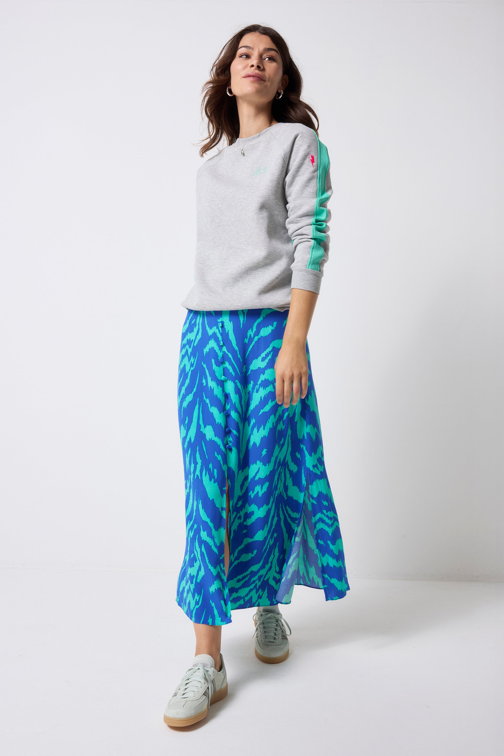Scamp and Dude Grey Marl with Turquoise Colourblock Relaxed Sweatshirt | Model wearing a grey crewneck sweatshirt with a blue and green tiger skirt.