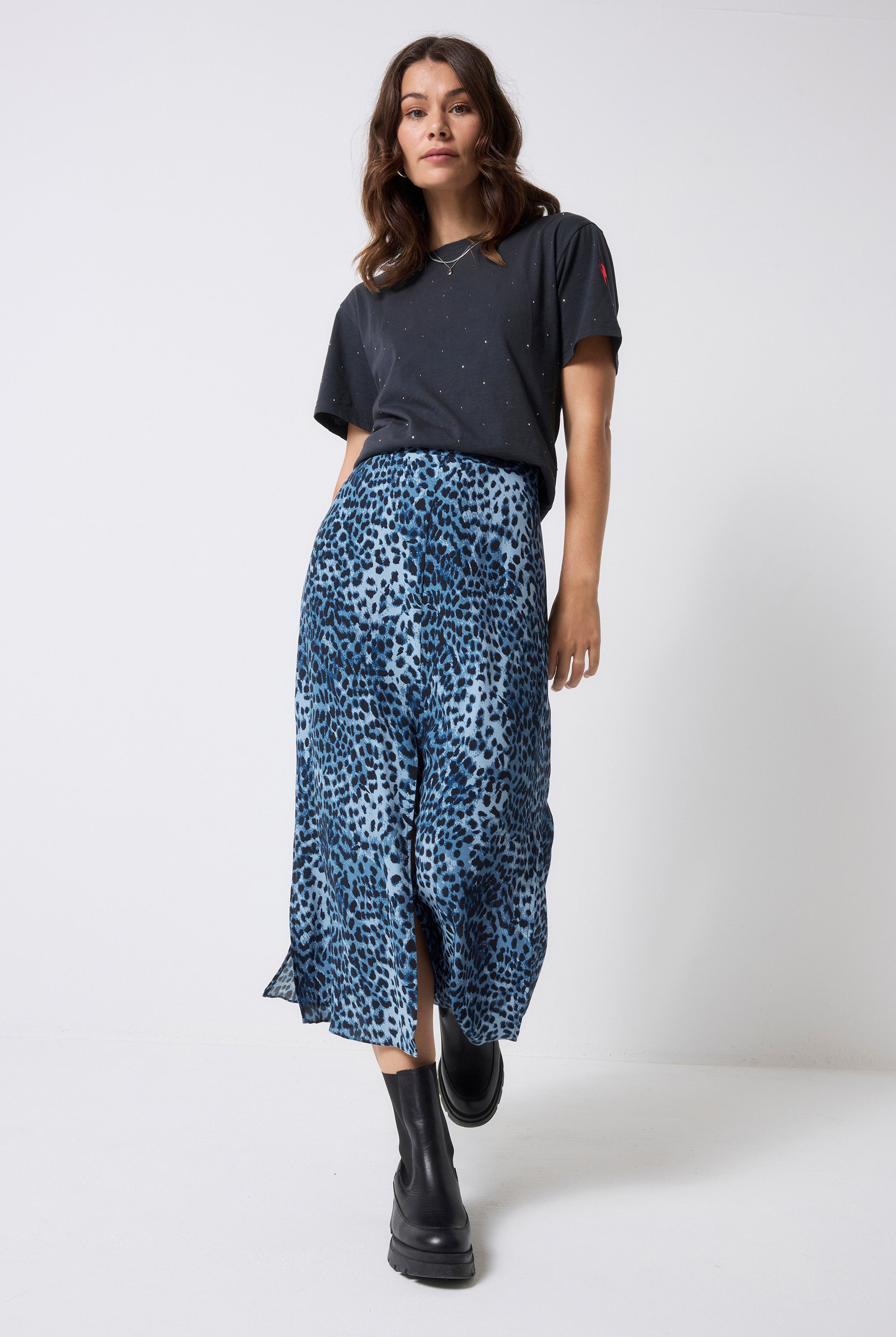 Scamp and Dude Navy Cheetah Midi Skirt | Model wearing a dark grey studded t-shirt with a navy blue cheetah print skirt and black boots.