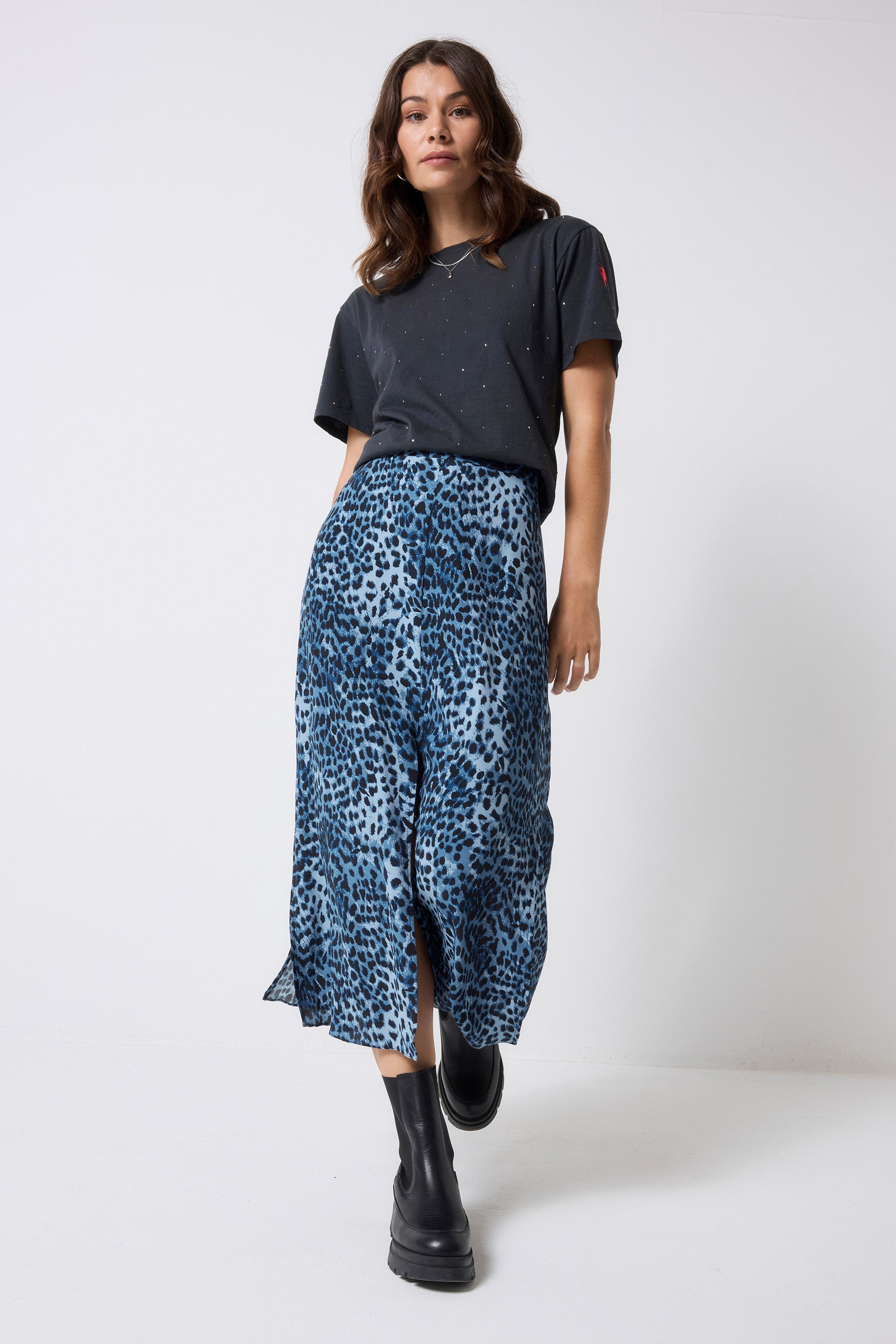 Scamp and Dude Navy Cheetah Midi Skirt | Model wearing a dark grey studded t-shirt with a navy blue cheetah print skirt and black boots.