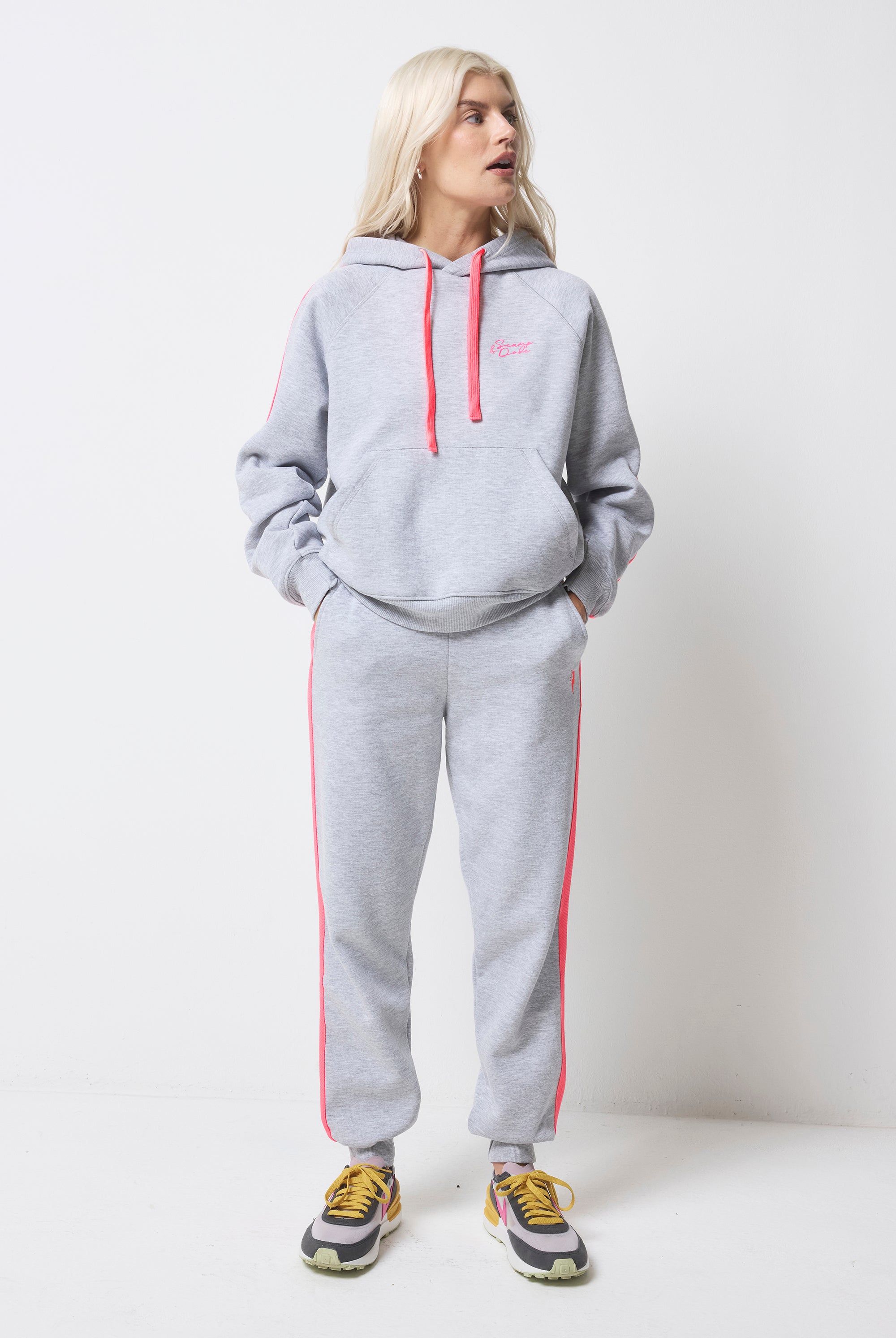 Scamp and Dude Light Grey Marl with Pink Colourblock Joggers | Model wearing light grey hoodie featuring a neon pink stripe and drawstring with matching joggers.