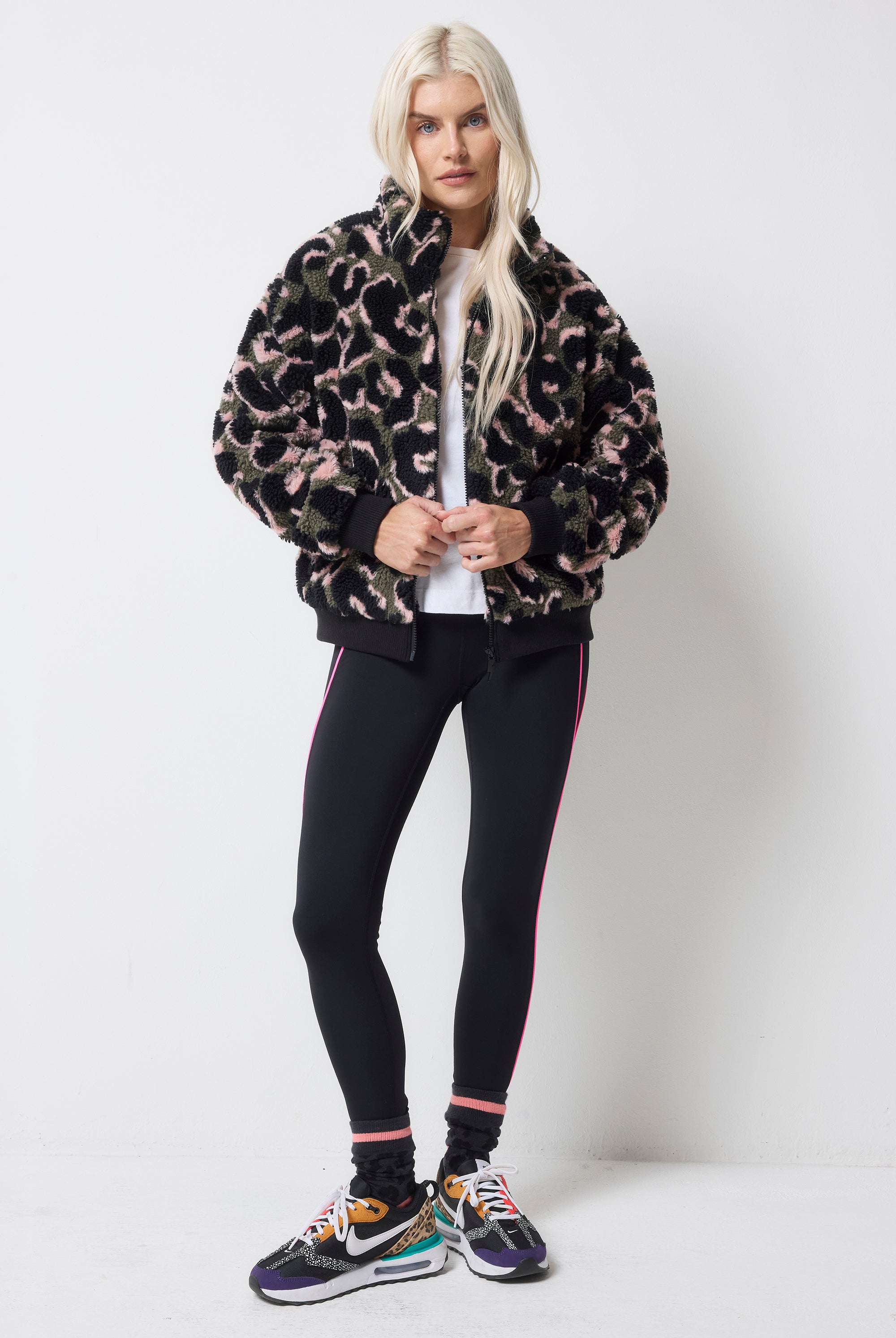 Scamp and Dude Khaki Leopard Fleece Bomber Jacket | Model wearing a pair of black leggings with a white t-shirt and a khaki leopard fleece.