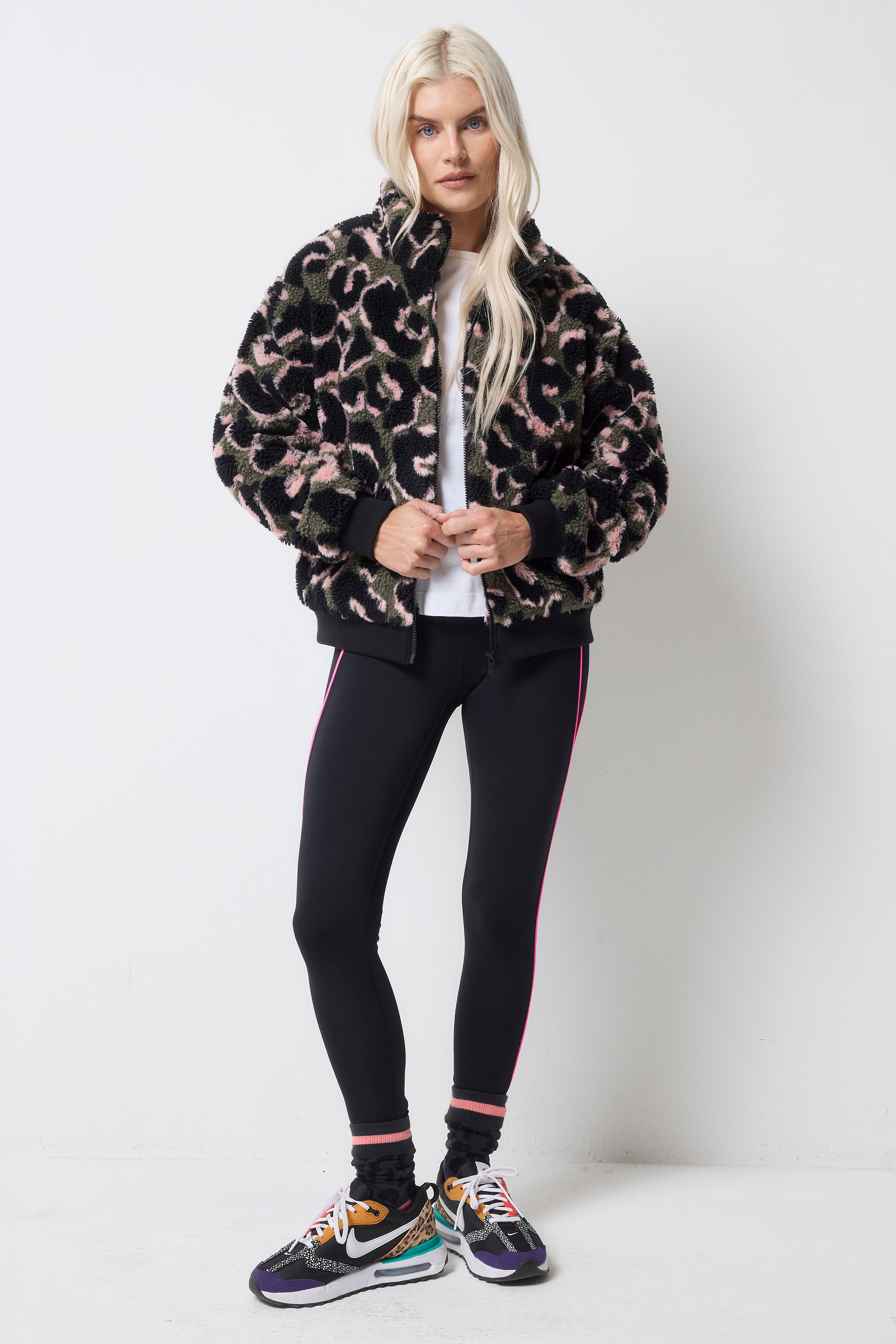 Scamp and Dude Khaki Leopard Fleece Bomber Jacket | Model wearing a pair of black leggings with a white t-shirt and a khaki leopard fleece.