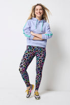 Scamp and Dude Navy Long Sleeve Jumper | Model wearing a blue hoodie with dark khaki leggings that feature rainbow leopard print. Worn with colourful trainers.