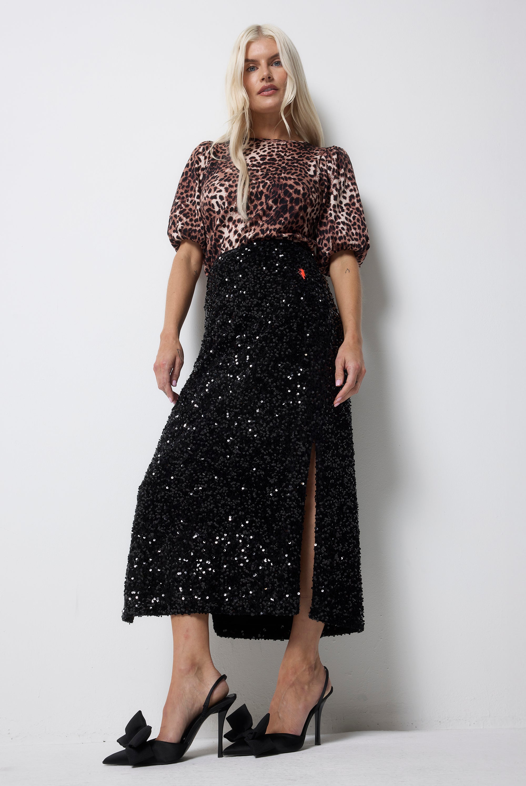 Scamp and Dude Black Sequin Velvet Midi Skirt | Model wearing a black sequin midi skirt with a neutral cheetah t-shirt and black heels.