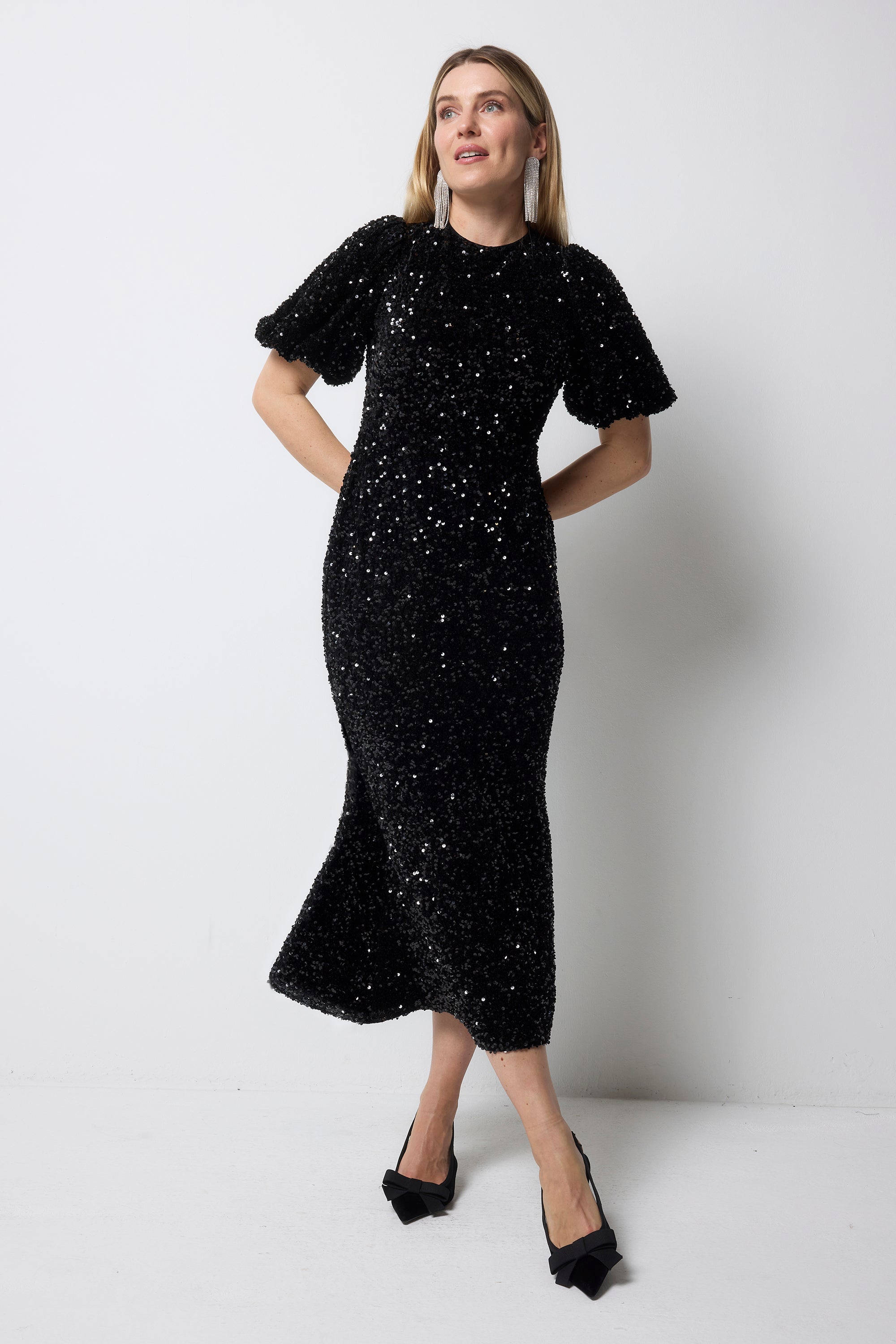 Scamp and Dude Black Sequin Tie Back Puff Sleeve Velvet Midi Dress | Model wearing a black sequin mini dress with a tie back detail.