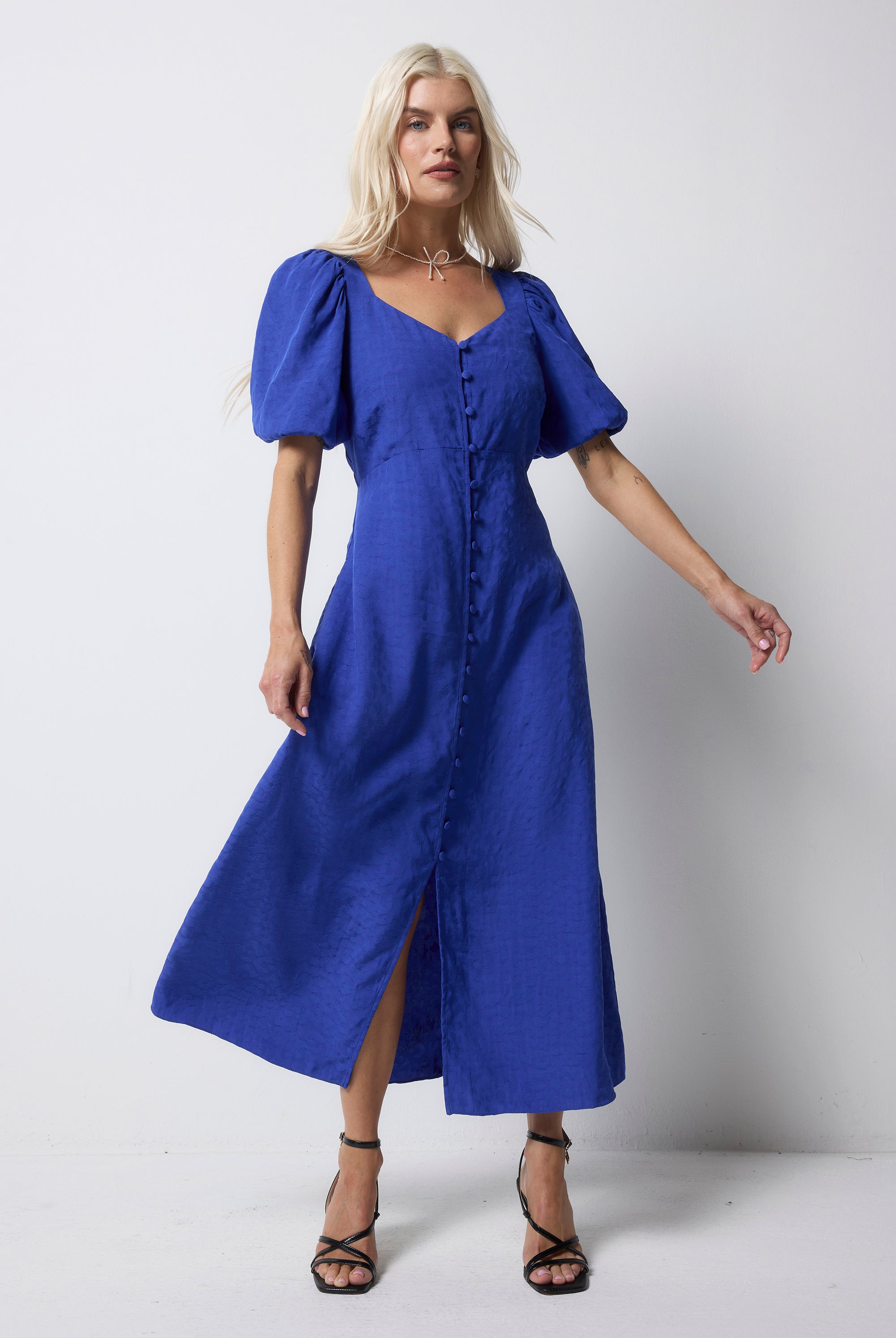 Scamp and Dude Blue Animal Jacquard Sweetheart Puff Sleeve Midi Tea Dress | Model wearing a blue jacquard animal dress with puff sleeves and button front details.