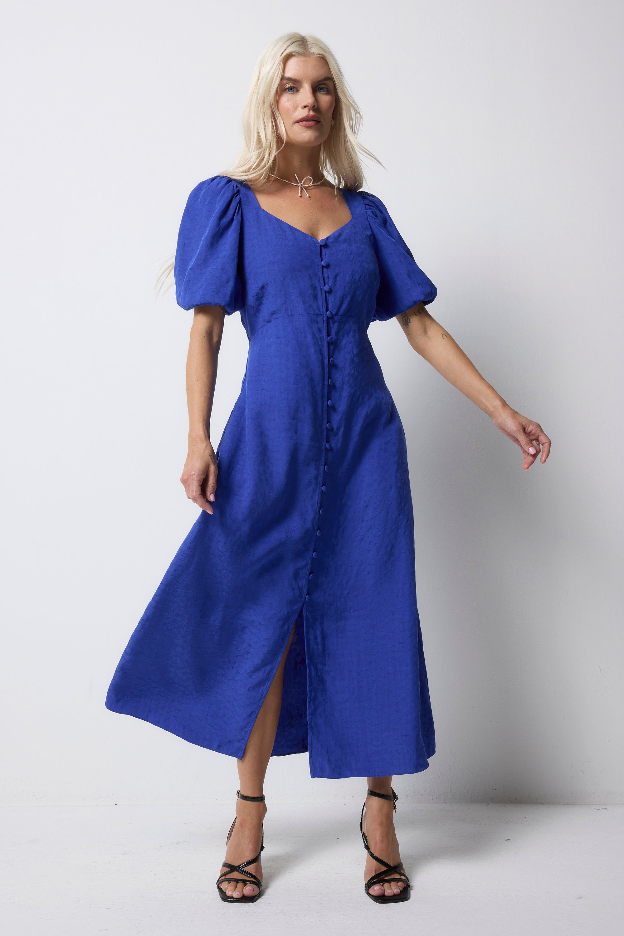 Scamp and Dude Blue Animal Jacquard Sweetheart Puff Sleeve Midi Tea Dress | Model wearing a blue jacquard animal dress with puff sleeves and button front details.