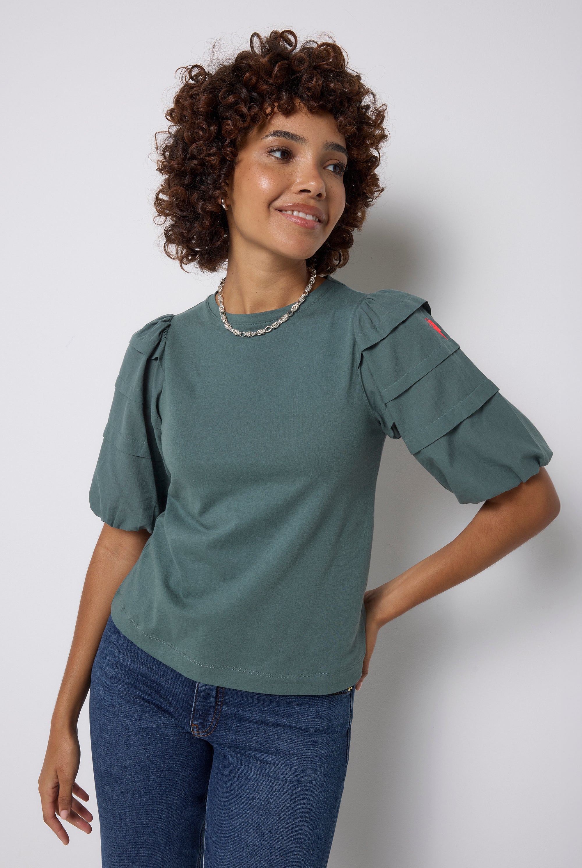 Scamp and Dude Khaki Pintuck Sleeve T-Shirt | Model wearing a pair of indigo jeans with a khaki pintuck sleeve t shirt.