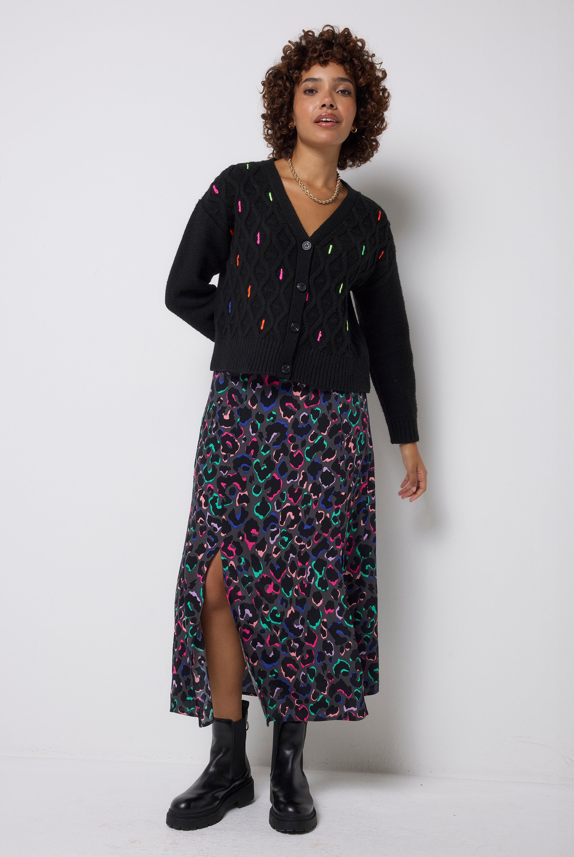 Scamp & Dude Grey with Rainbow Ziggy Leopard Split Front Skirt | Model wearing a black cardigan featuring neon flecks and a patterned skirt with black chunky boots.