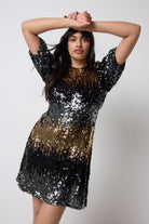 Scamp and Dude Copper Ombre Sequin Puff Sleeve Short Dress | Model wearing a short puff sleeve dress with ombre sequin detail paired with black heeled boots.