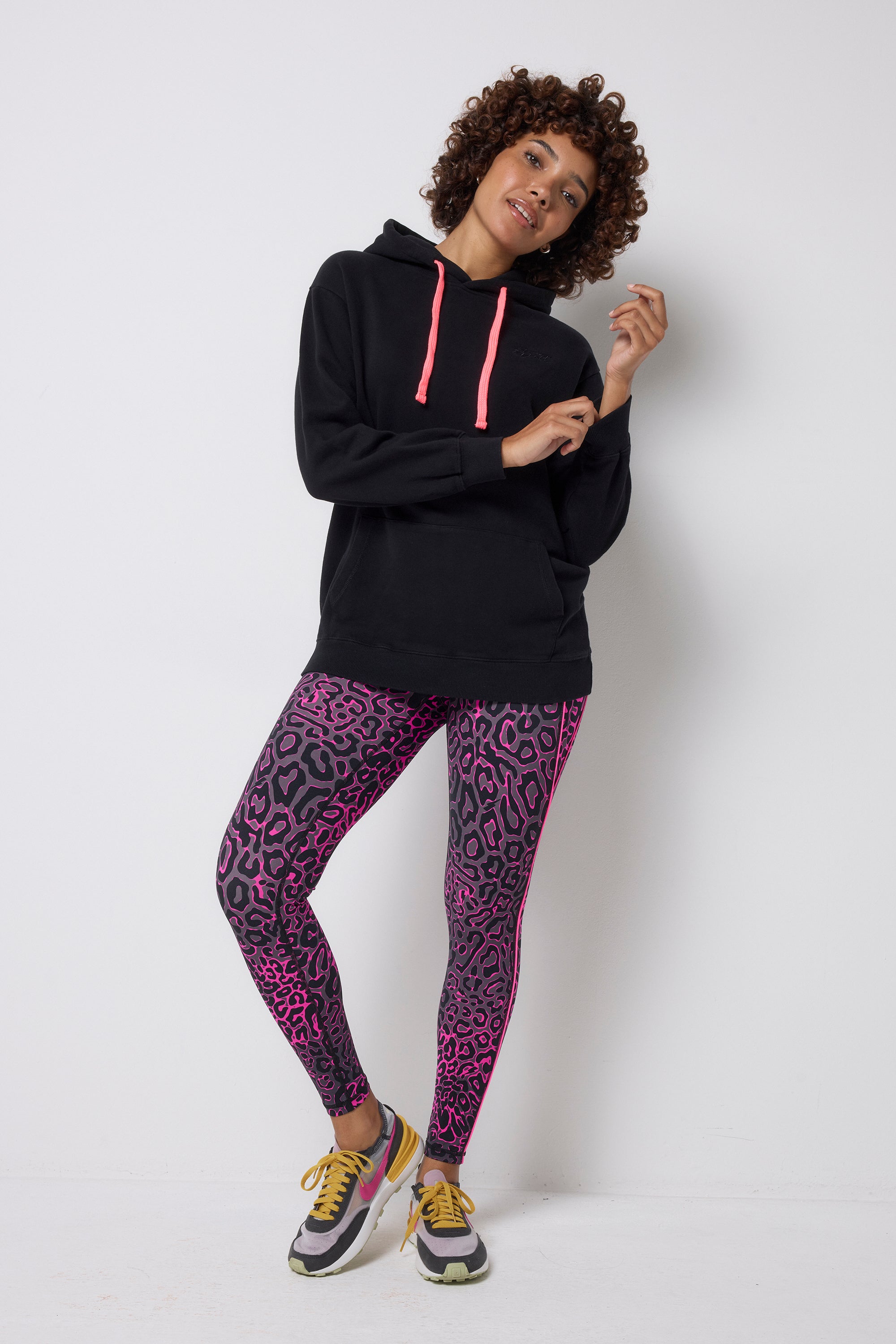 Scamp and Dude Grey with Pink Leopard Ray Full Length Active Leggings | Model wearing a black hoodie with grey and pink leopard ray print leggings.