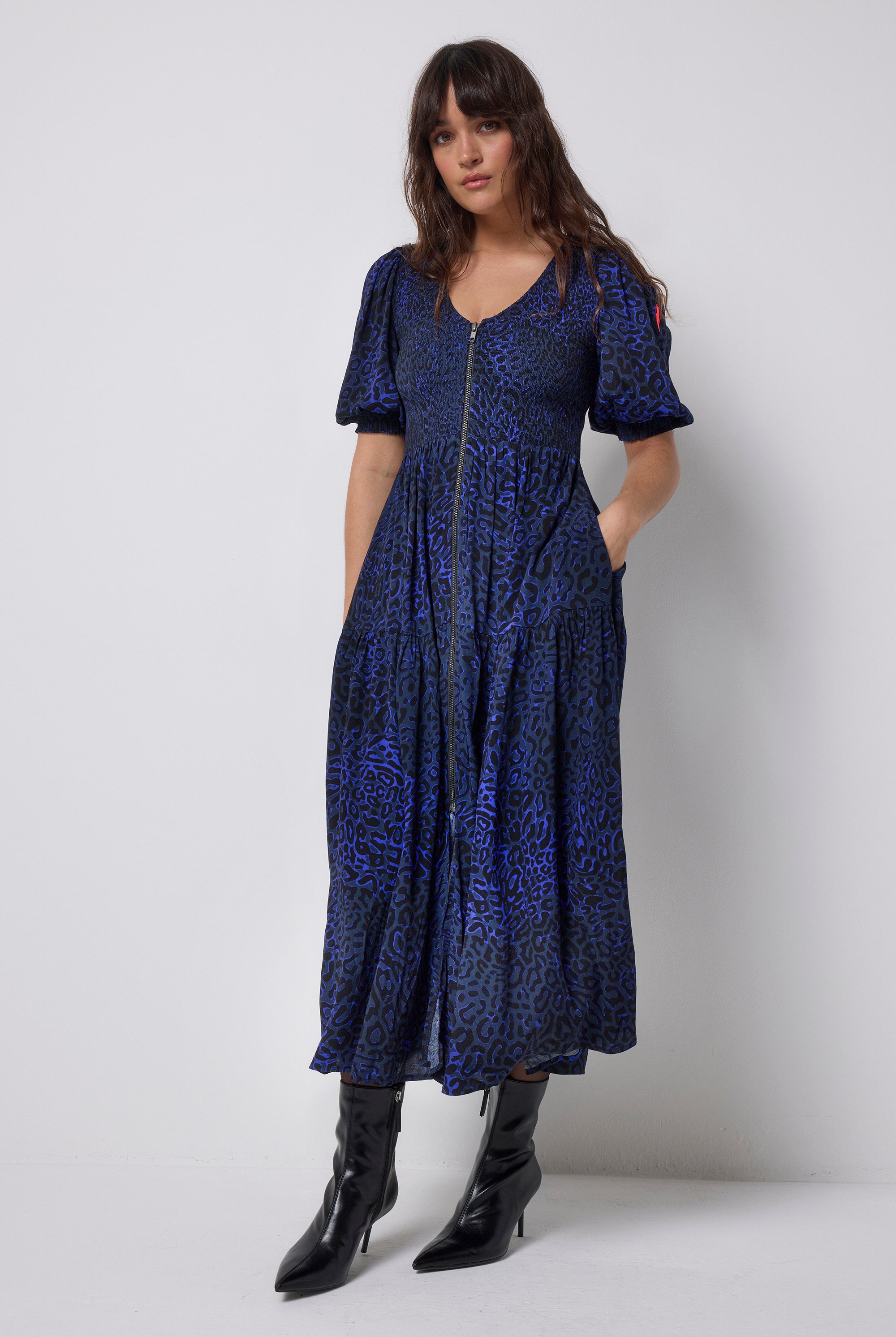 Scamp and Dude Navy Leopard Ray Shirred Zip Detail Midi Dress | Model wearing navy zip front dress in a leopard ray print with black heeled boots.