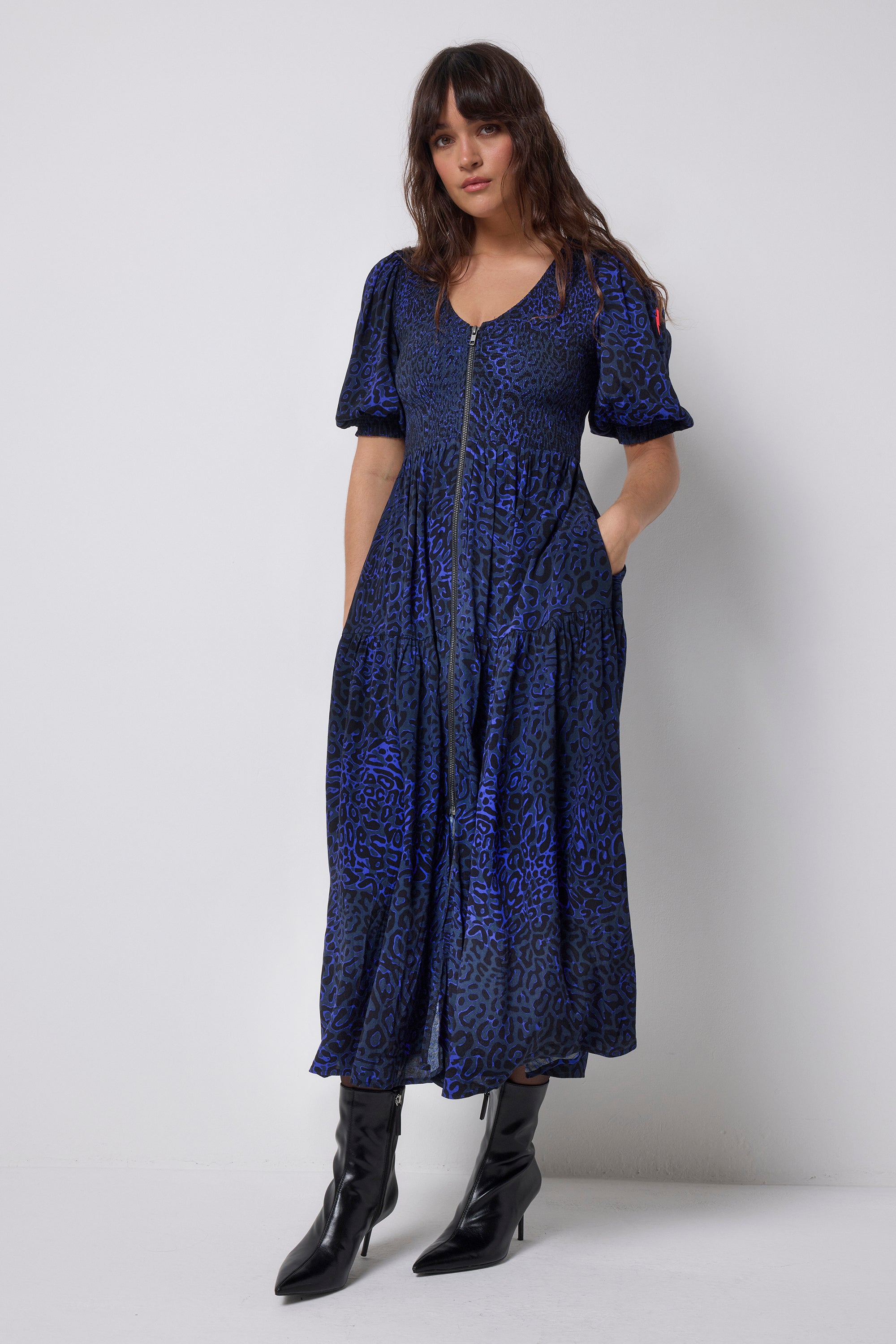 Scamp and Dude Navy Leopard Ray Shirred Zip Detail Midi Dress | Model wearing navy zip front dress in a leopard ray print with black heeled boots.