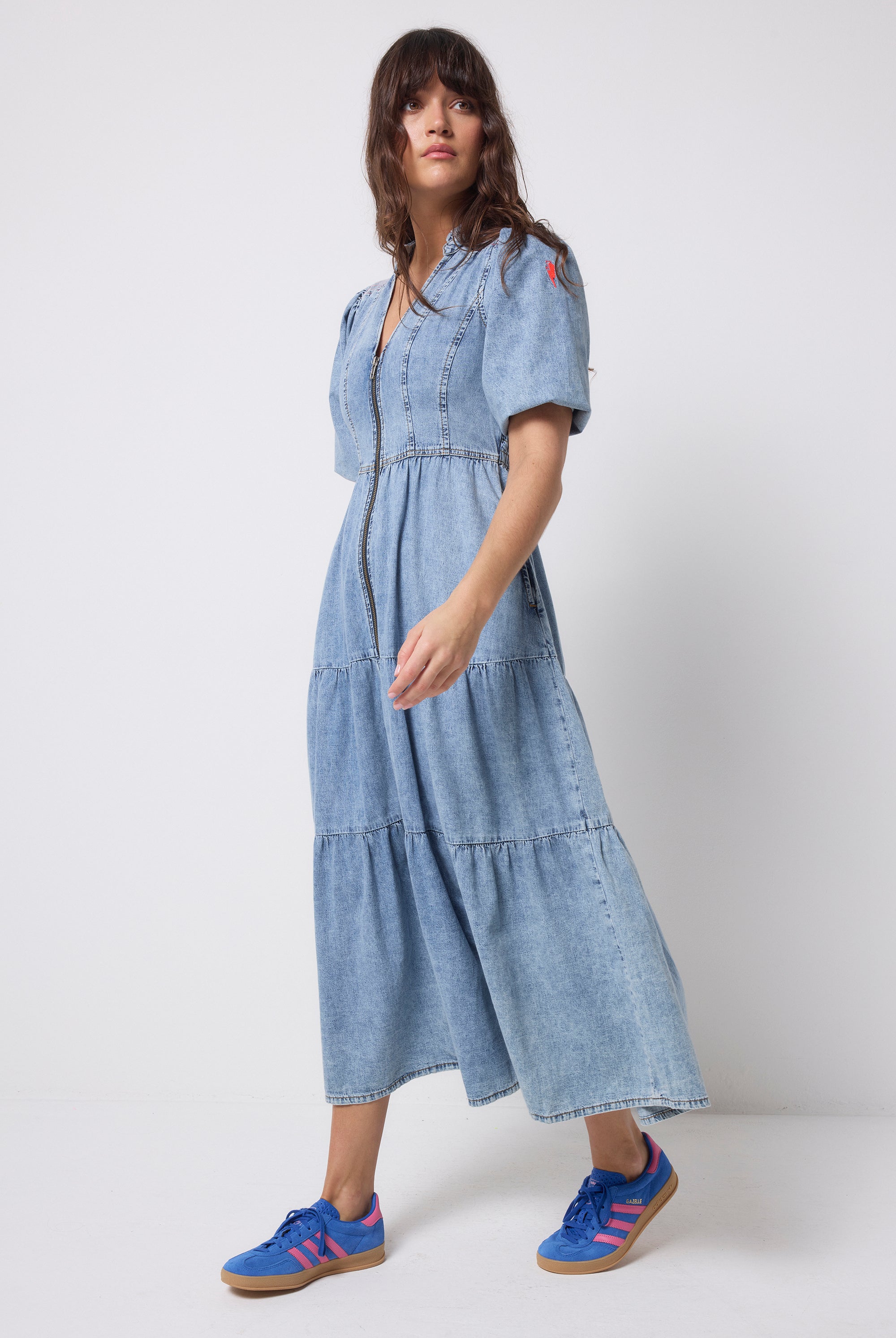 Scamp and Dude Pale Indigo Zip Detail Tiered Midi Denim Dress | Model wearing a pale wash denim dress with a zip through front and tiered skirt.