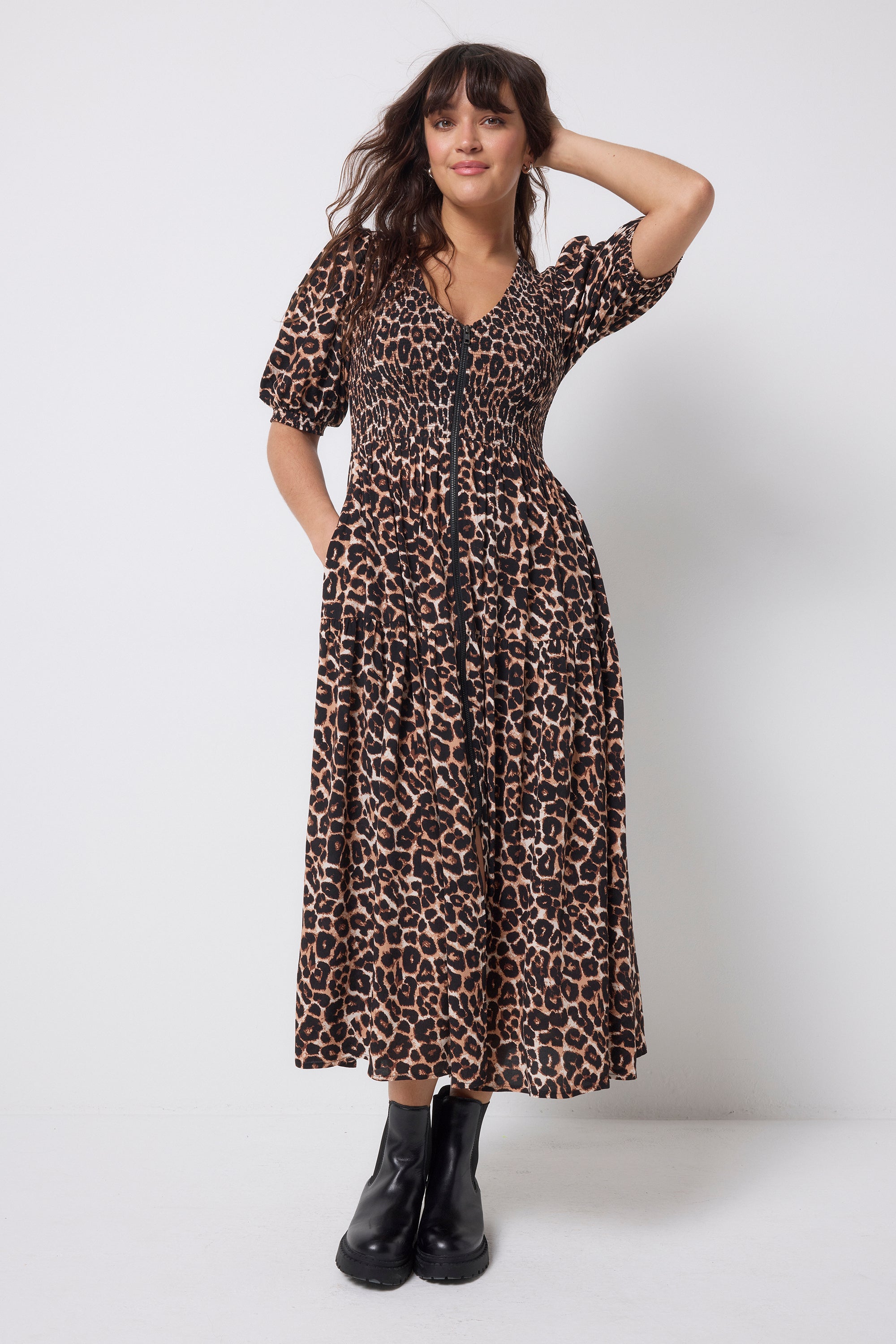 Scamp and Dude Neutral Jaguar Shirred Zip Detail Midi Dress | Model wearing a neutral jaguar print dress with a zip front detail. Paired with black boots.