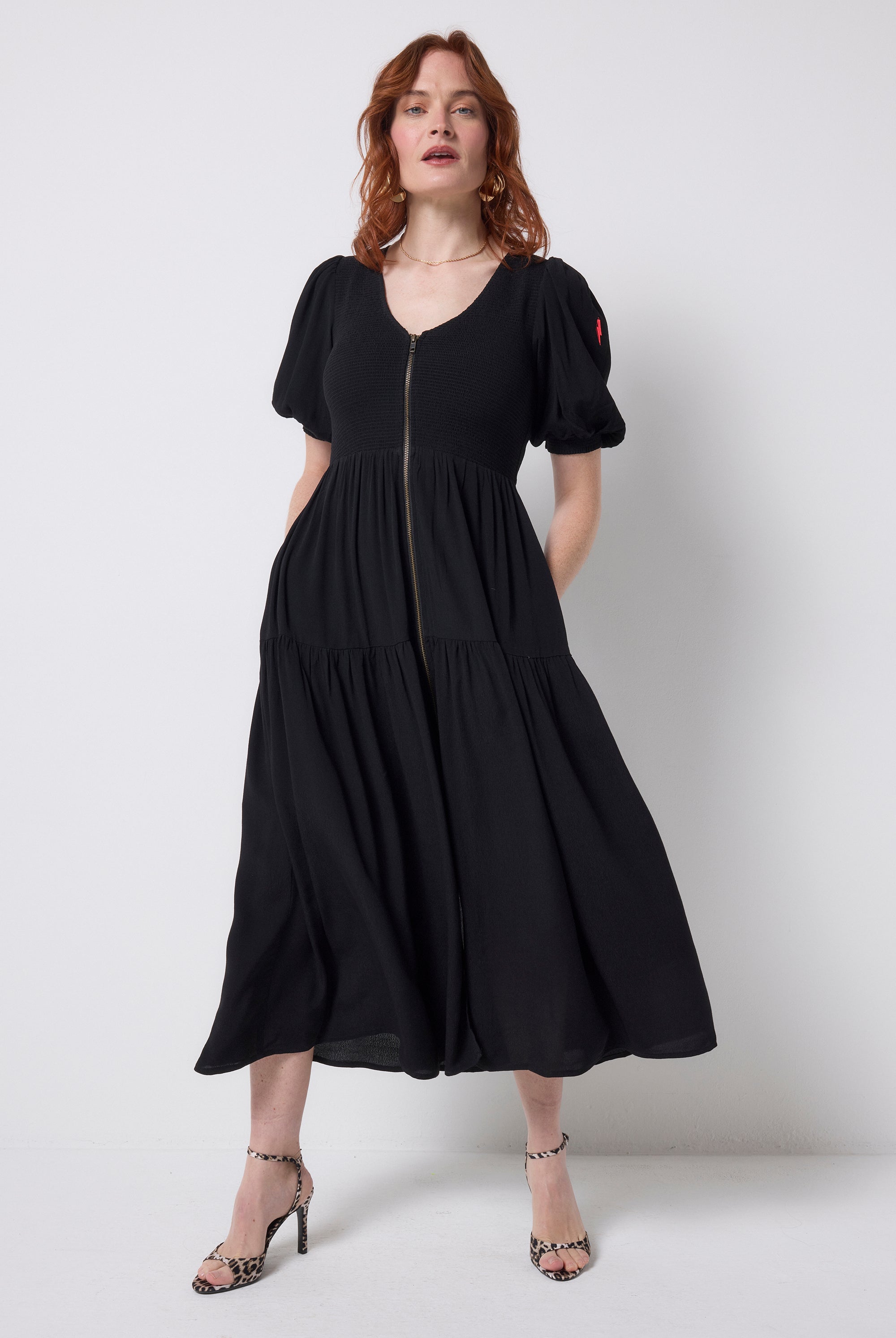 Scamp and Dude Black Shirred Zip Detail Midi Dress | Model wearing a black v-neck zip front dress with leopard print high heels.