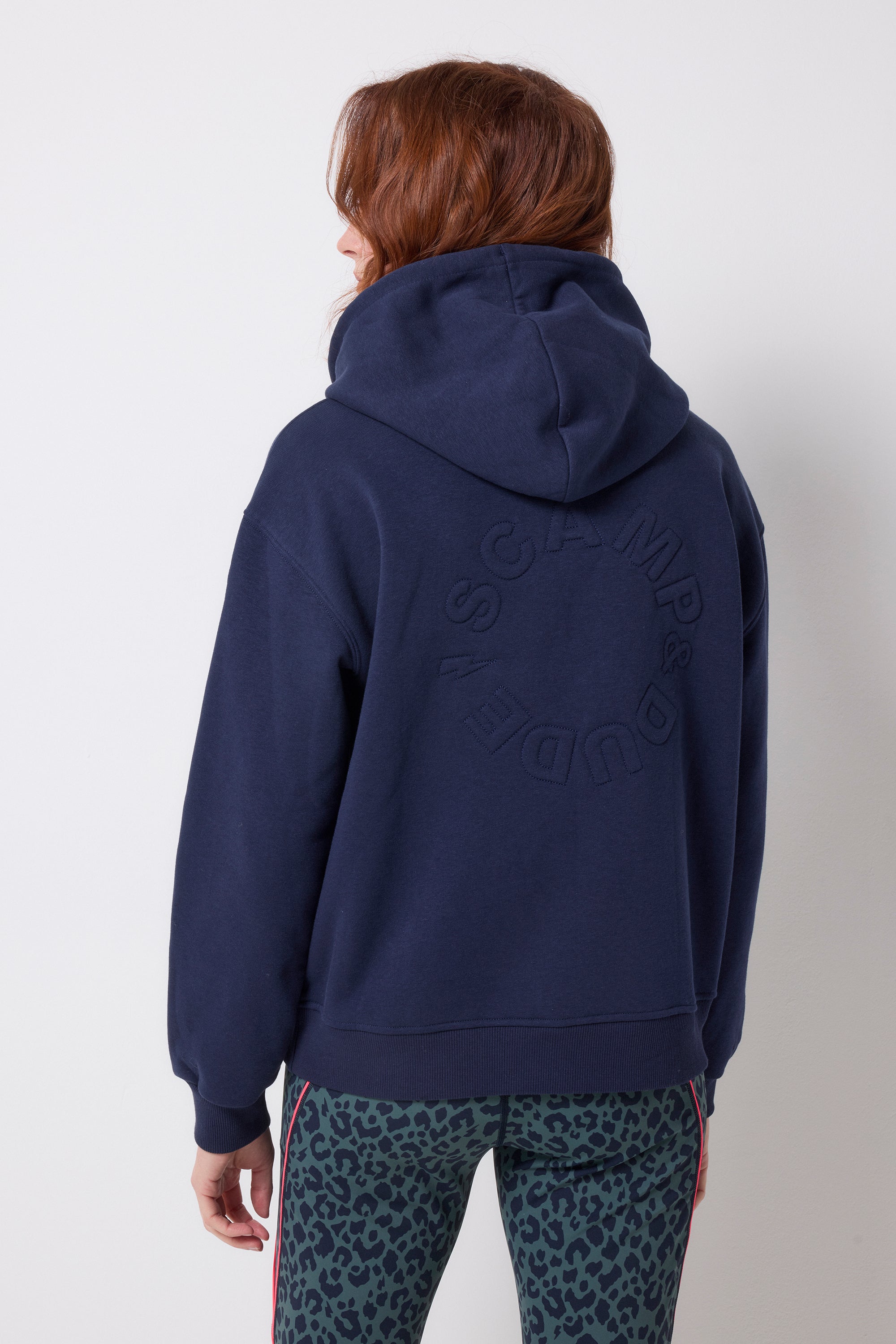 Scamp and Dude Navy Embroidered Logo Ultimate Hoodie | Model wearing a navy hoodie with a pair of leopard print leggings.