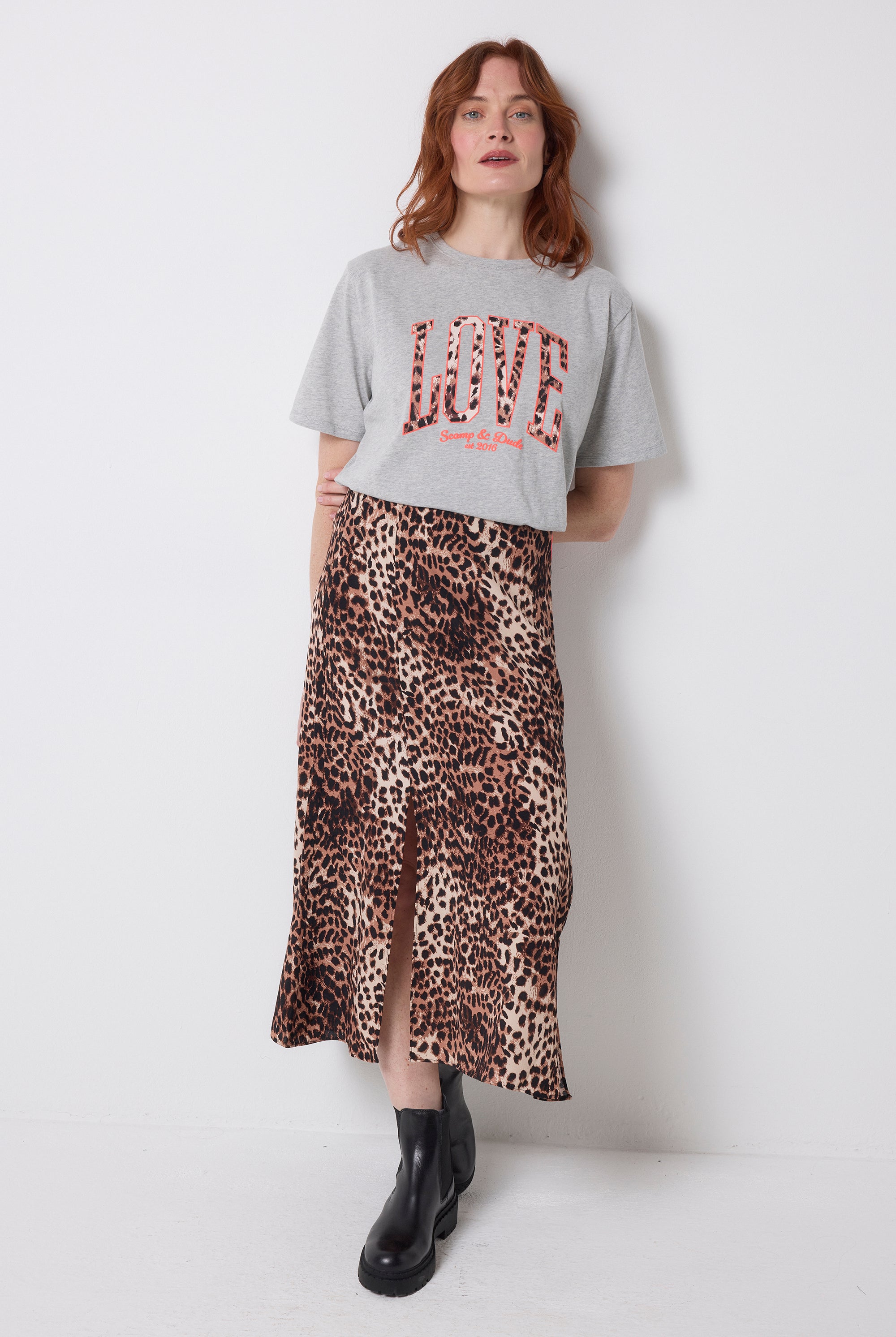 Scamp and Dude Grey Marl Love Cheetah T-Shirt | Model wearing a neutral cheetah print skirt with a grey t-shirt featuring love cheetah print.