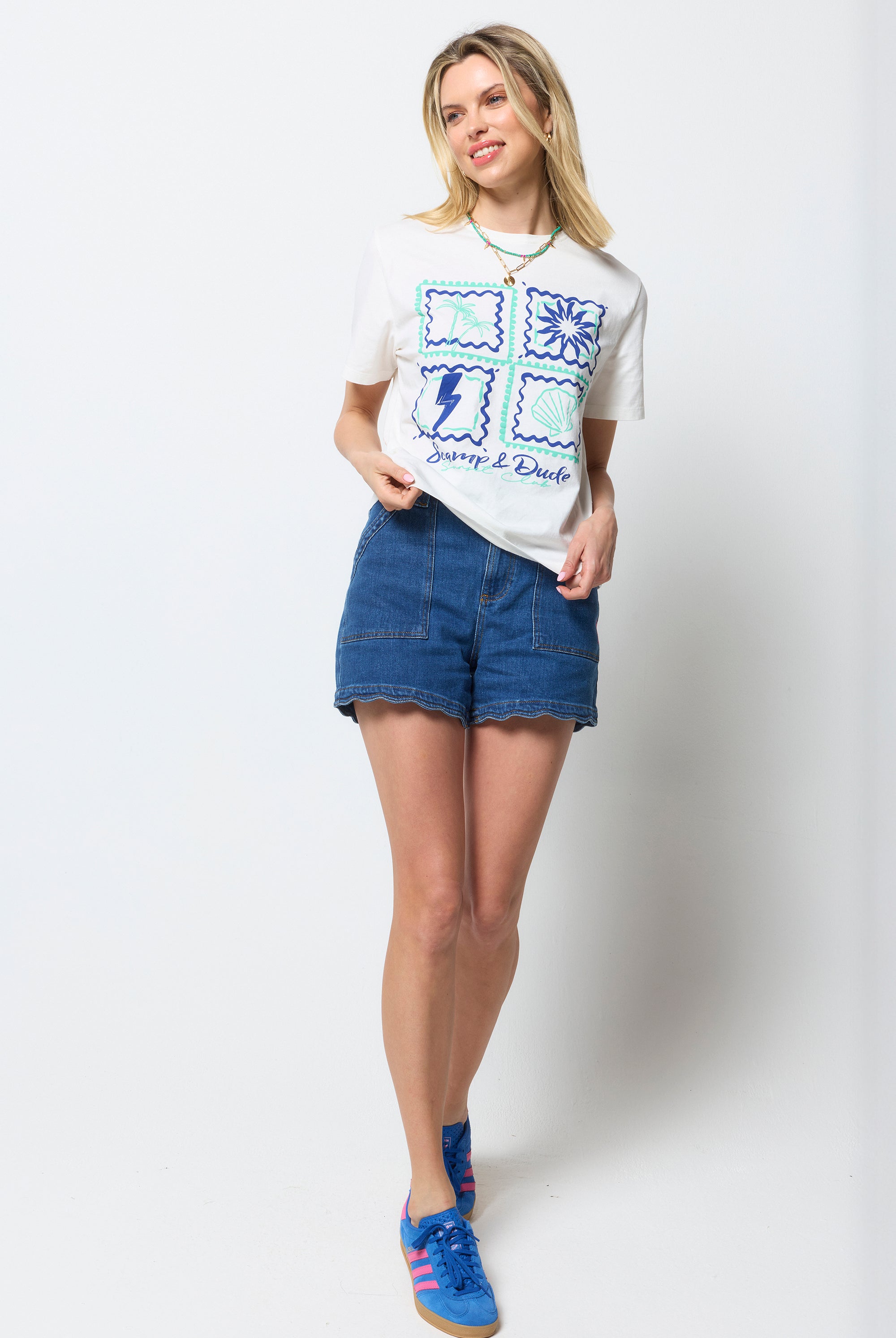 Scamp and Dude Ecru Tile Print T-Shirt | Model wearing an ecru tile print t-shirt with blue denim shorts and blue trainers.