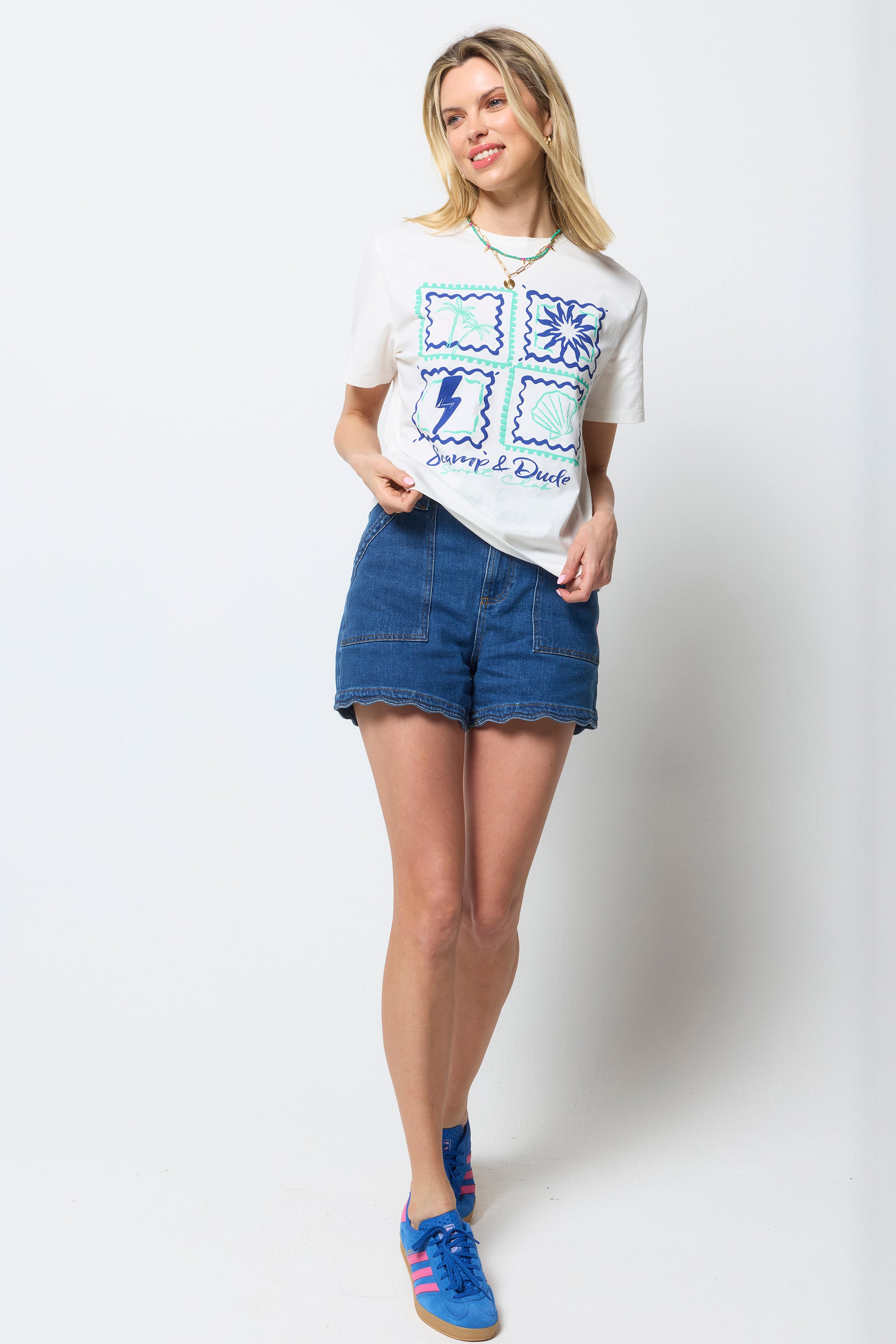Scamp and Dude Ecru Tile Print T-Shirt | Model wearing an ecru tile print t-shirt with blue denim shorts and blue trainers.