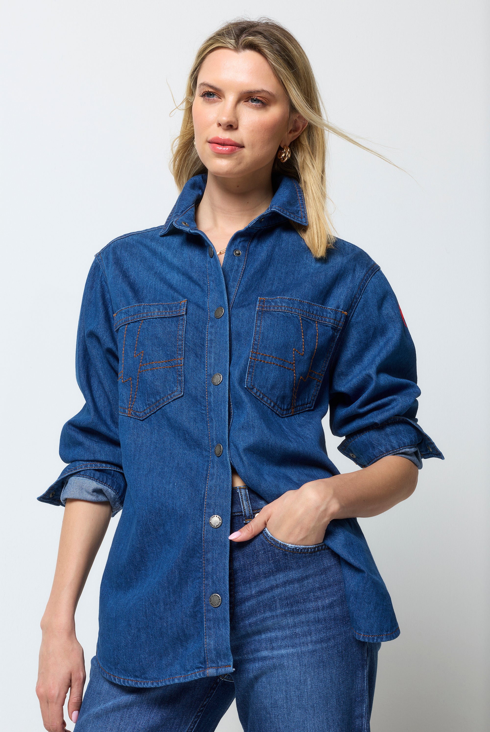 Scamp & Dude Mid Wash Indigo Relaxed Denim Shirt | Model wearing a dark blue denim shirt and distressed jeans.