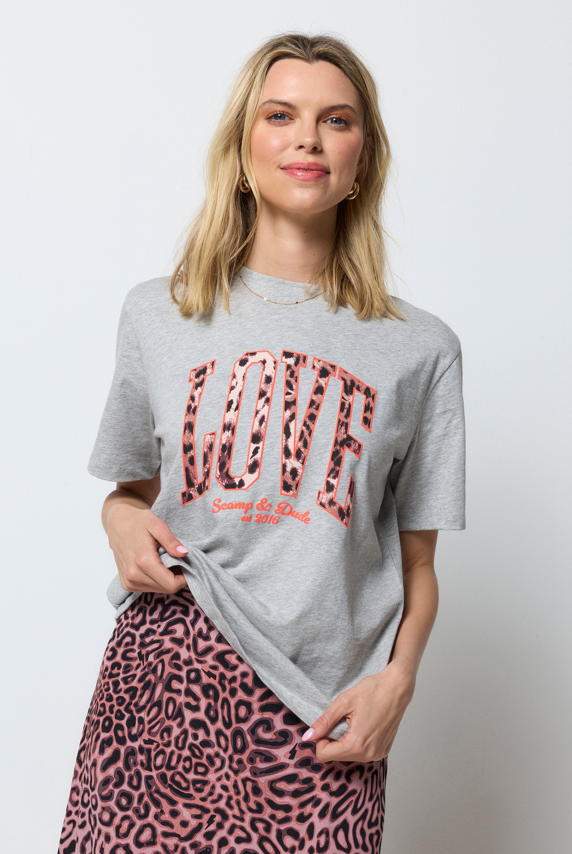 Scamp and Dude Grey Marl Love Cheetah T-Shirt | Model wearing a neutral leopard ray print skirt with a grey t-shirt featuring love cheetah print.