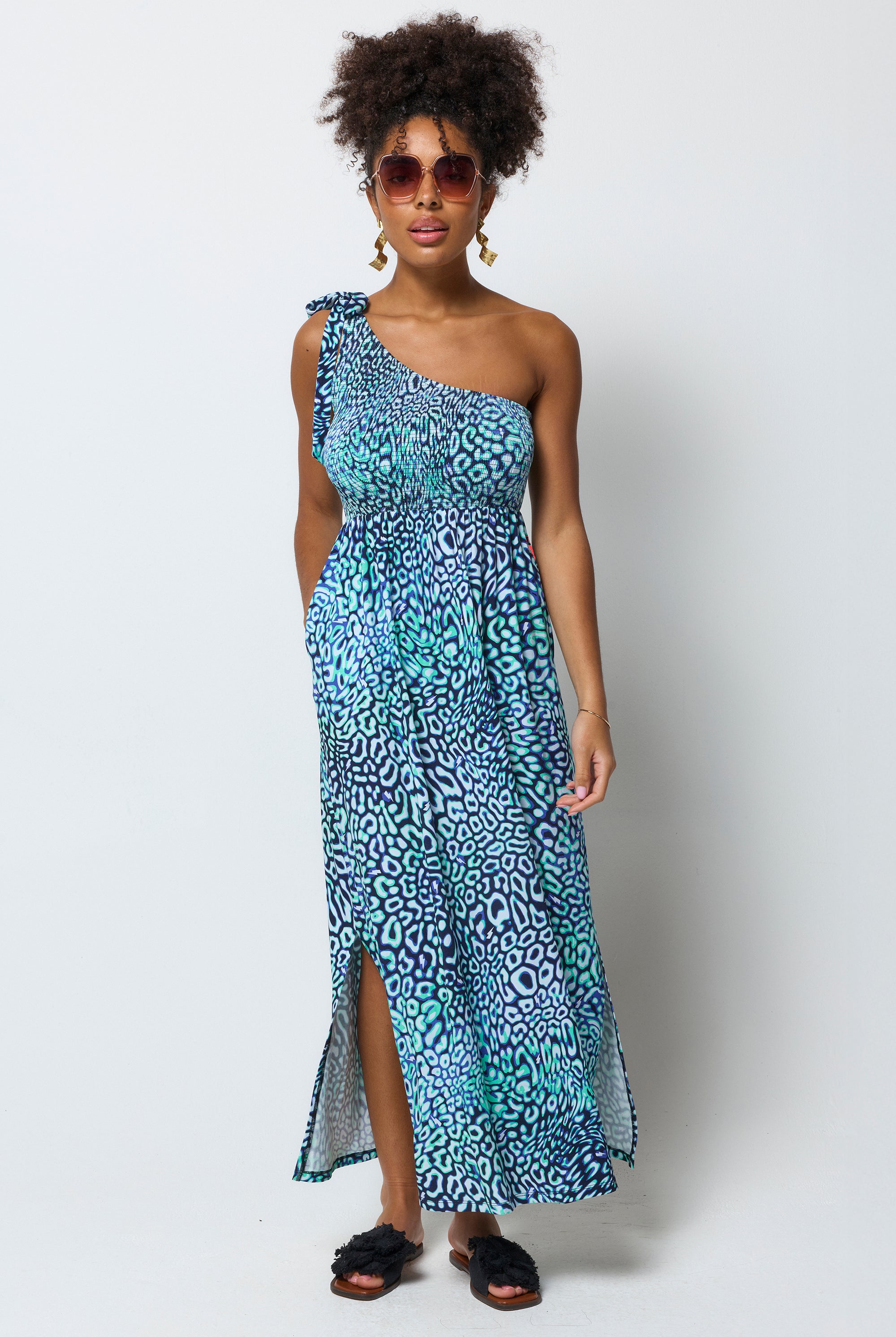 Scamp and Dude Green Leopard Ray One Shoulder Maxi Dress | Model wearing a green one shoulder maxi dress in a leopard ray print. Worn with black sandals.