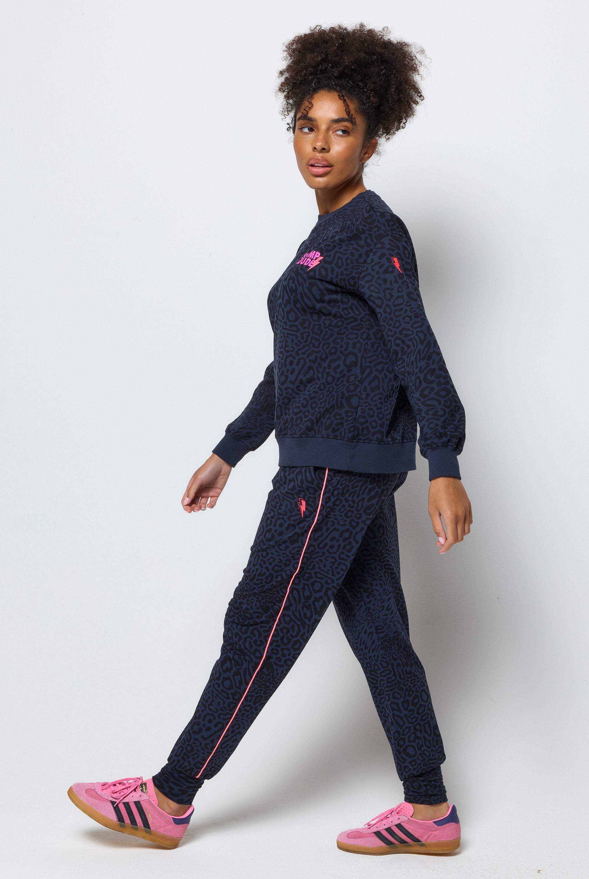 Scamp and Dude Navy with Black Leopard Ray Slouch Joggers | Model wearing navy leopard ray print joggers with a matching sweatshirt and colourful trainers.